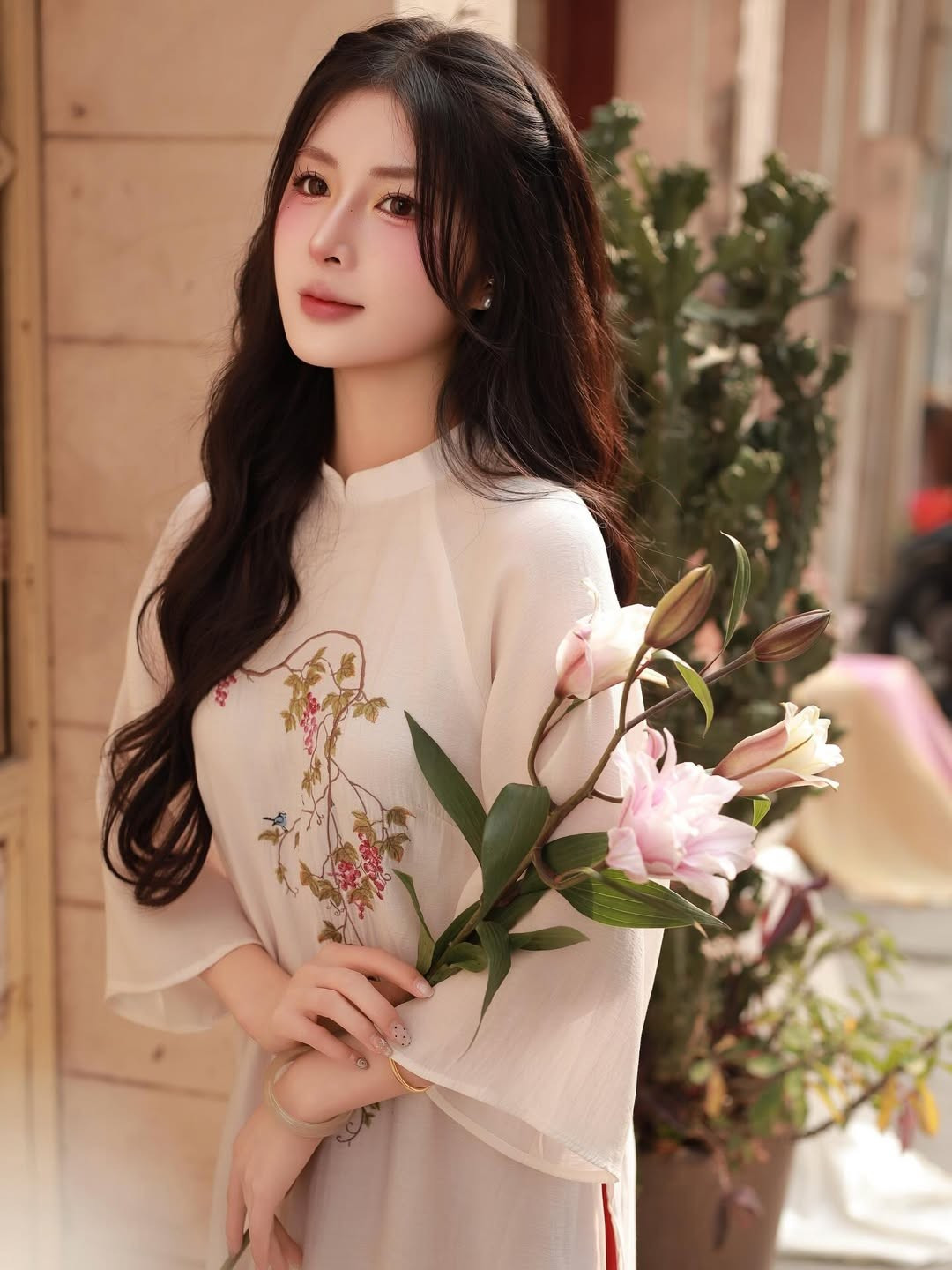 Trên thân áo, những họa tiết hoa và chim muông được thêu tay tỉ mỉ với màu sắc nhã nhặn, vừa tạo điểm nhấn thanh lịch, vừa gợi nhớ đến không gian mùa xuân tràn đầy sức sống. (Ảnh: IGNV)