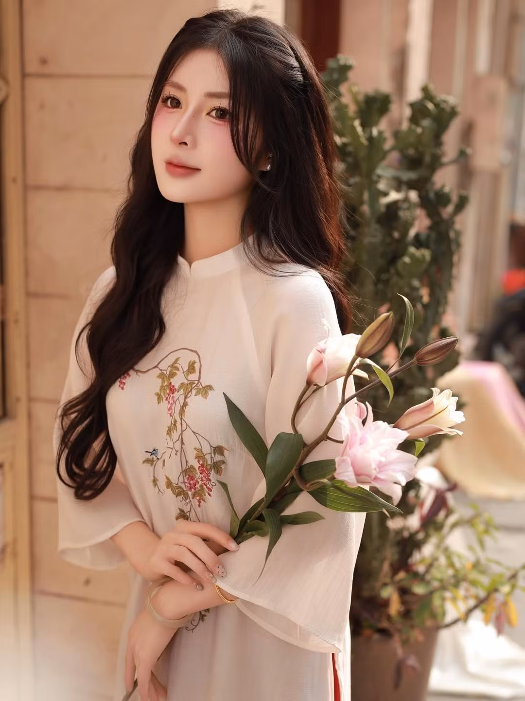 Trên thân áo, những họa tiết hoa và chim muông được thêu tay tỉ mỉ với màu sắc nhã nhặn, vừa tạo điểm nhấn thanh lịch, vừa gợi nhớ đến không gian mùa xuân tràn đầy sức sống. (Ảnh: IGNV)