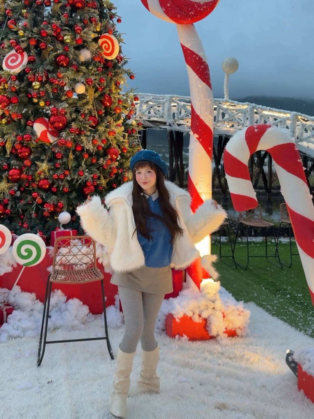 Loạt ảnh được chụp tại địa điểm được trang trí công phu theo chủ đề Giáng sinh, với những cây thông lấp lánh, cổng vòm vàng đỏ rực rỡ, tượng người tuyết khổng lồ ngộ nghĩnh, và đặc biệt là lớp tuyết nhân tạo trắng xóa phủ đầy lối đi và bậc thang. (Ảnh: IGNV)