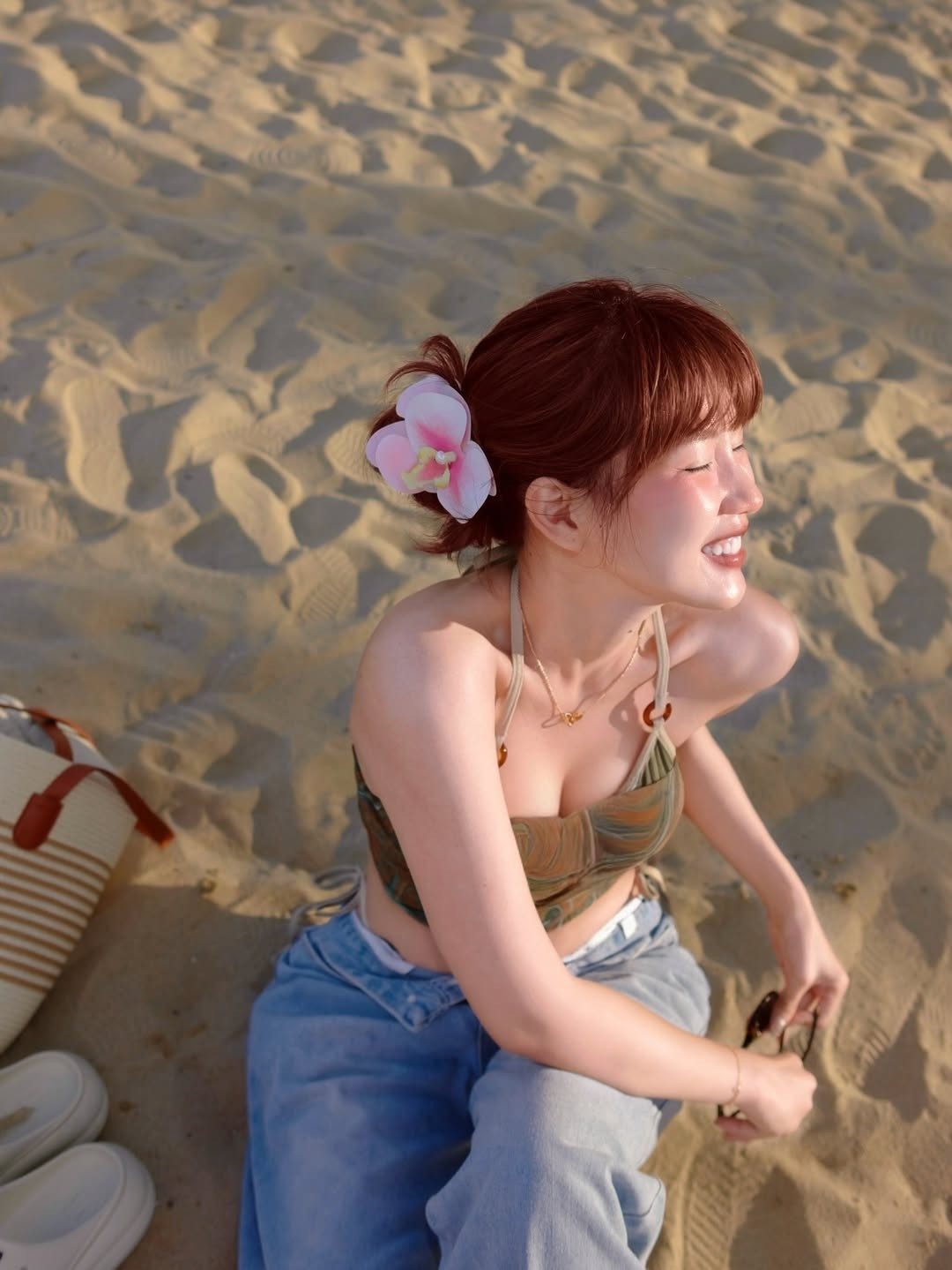 Trong loạt ảnh được chia sẻ, Kiều Trinh Xíu xuất hiện với mái tóc màu nâu đỏ nổi bật, được búi gọn gàng và cài thêm bông hoa phong lan màu hồng ngọt ngào, tạo điểm nhấn đầy nữ tính.