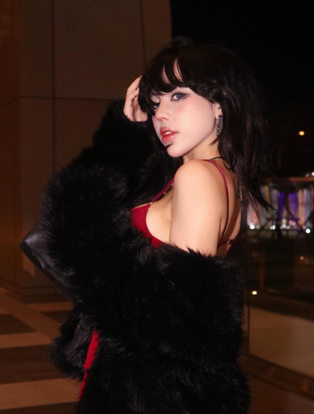 Cô nàng hot girl đình đám Bảo Khuyên Susan lựa chọn cho mình chiếc váy body đỏ rực rỡ, kết hợp cùng áo khoác lông và tất lưới tạo nên vẻ ngoài quyền lực, cực kỳ nổi bật dưới ánh đèn vàng.( Ảnh: IG @baokhuyen.susan)