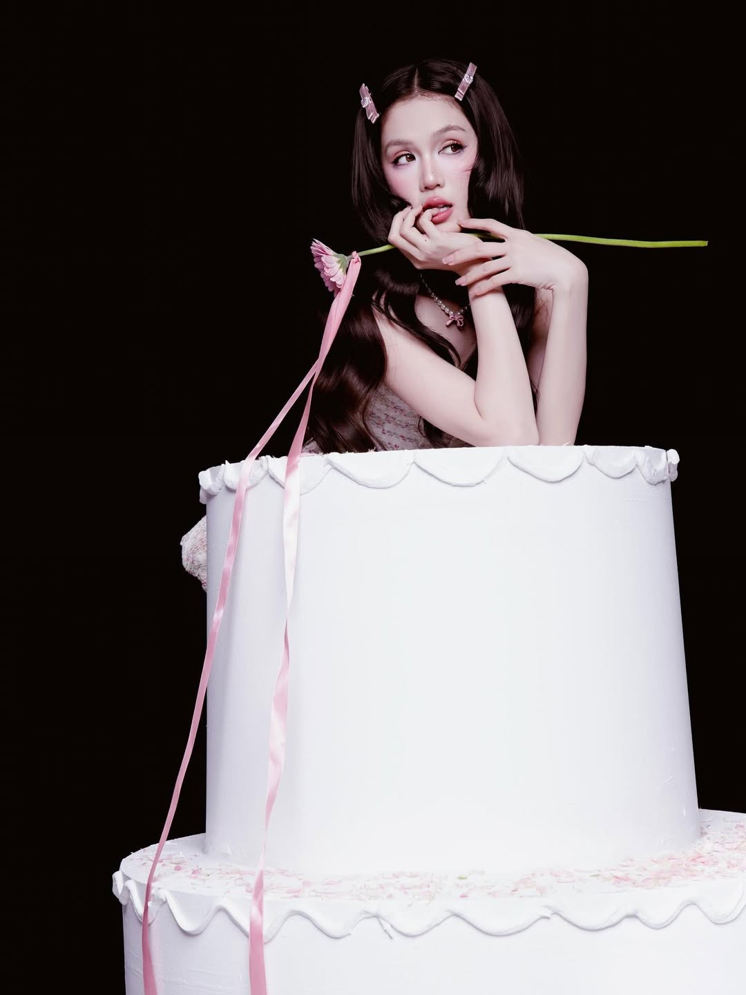 Với mái tóc dài đen được kẹp nơ hồng và lối trang điểm sắc sảo, Ngọc Trinh xuất hiện vừa ngọt ngào vừa gợi cảm. (Ảnh: IGNV)