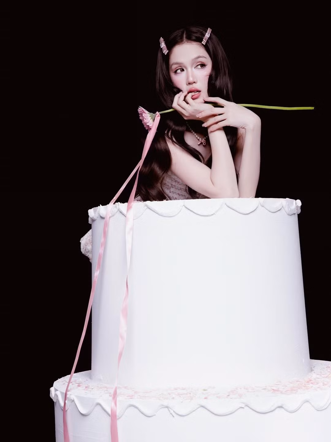 Với mái tóc dài đen được kẹp nơ hồng và lối trang điểm sắc sảo, Ngọc Trinh xuất hiện vừa ngọt ngào vừa gợi cảm. (Ảnh: IGNV)