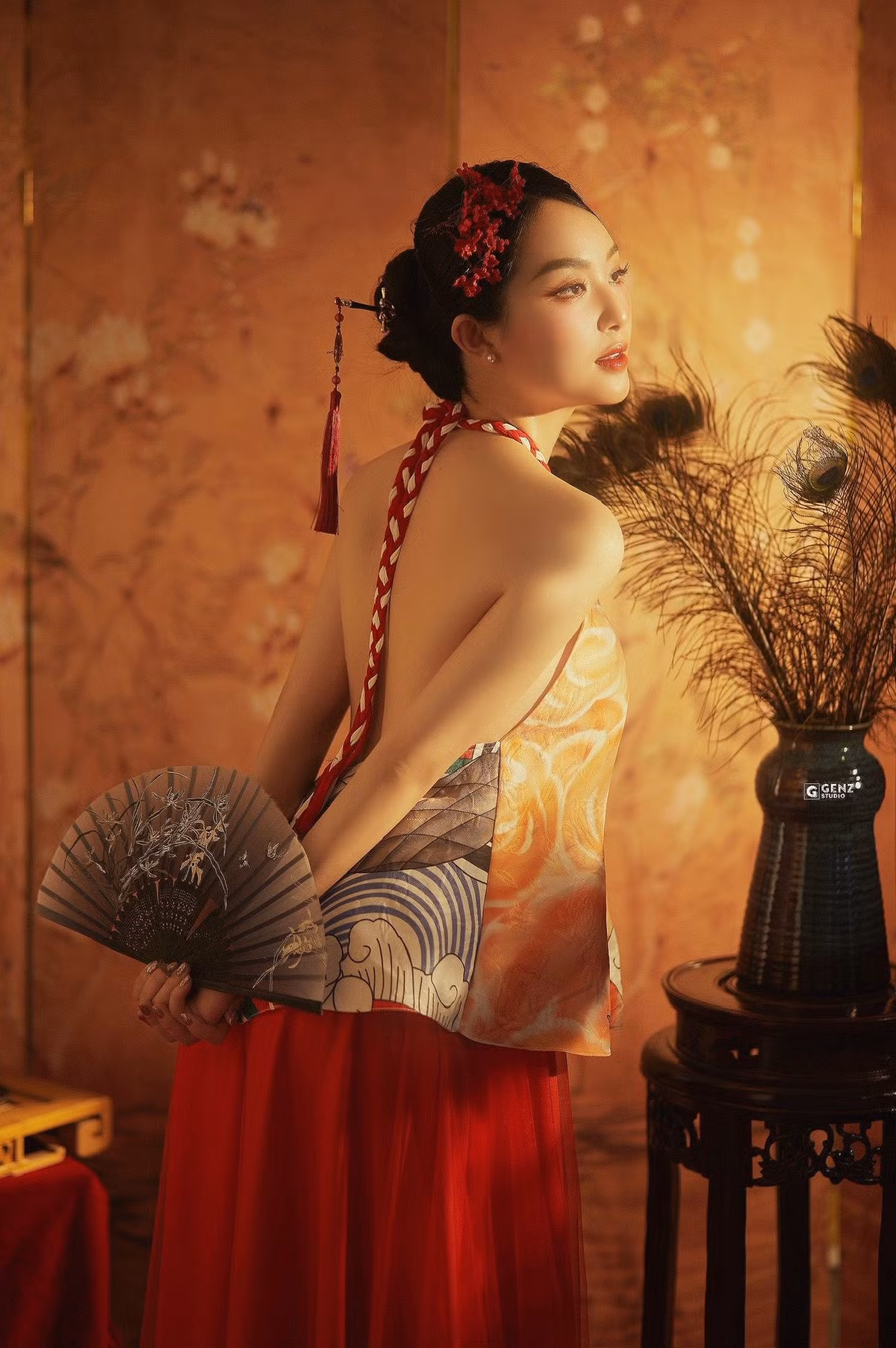 Phần cổ yếm được thay bằng dây đan tết màu đỏ và trắng, nổi bật trên tông vàng cam của áo, đặc biệt là thiết kế hở lưng táo bạo giúp nữ MC khoe trọn tấm lưng trần gợi cảm và duyên dáng. (Ảnh: FBNV)