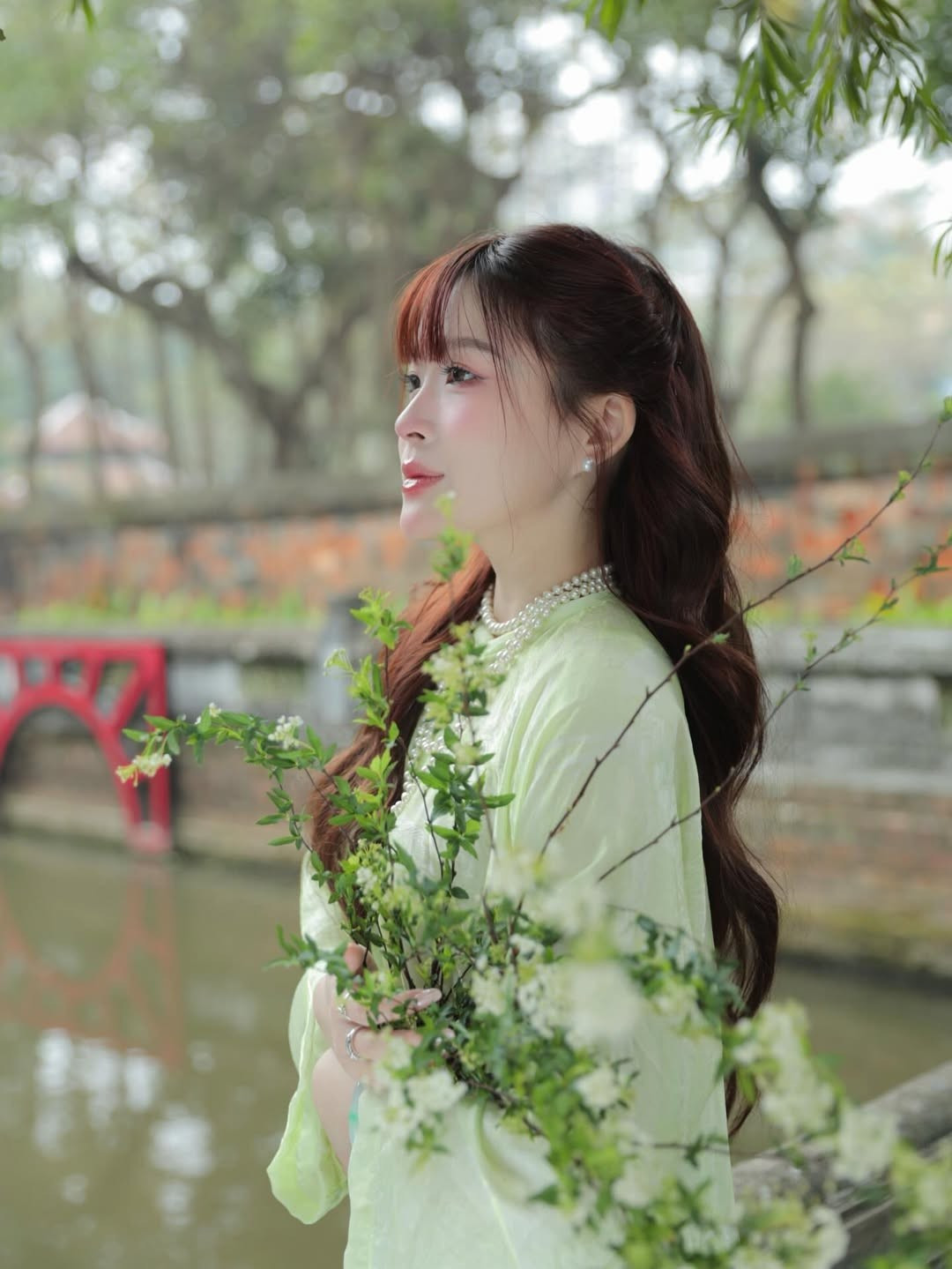 Thay vì chọn những gam màu quá rực rỡ, Chao xuất hiện đầy thanh tao trong thiết kế áo dài màu xanh cốm dịu mát. Đây là tông màu cực kỳ tôn da, giúp làm nổi bật làn da trắng sứ và gương mặt thanh tú của nàng hot girl sinh năm 2003. (Ảnh: IGNV)