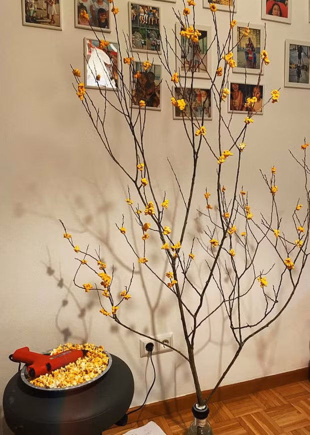 Sáng tạo nhất phải kể đến màn dùng bắp rang bơ gắn lên cành khô để giả làm hoa mai. Không chỉ đẹp mắt, "hoa" này còn có mùi thơm bơ ngào ngạt, khách đến chơi nhà nếu đói bụng có thể... hái ăn luôn tại chỗ.