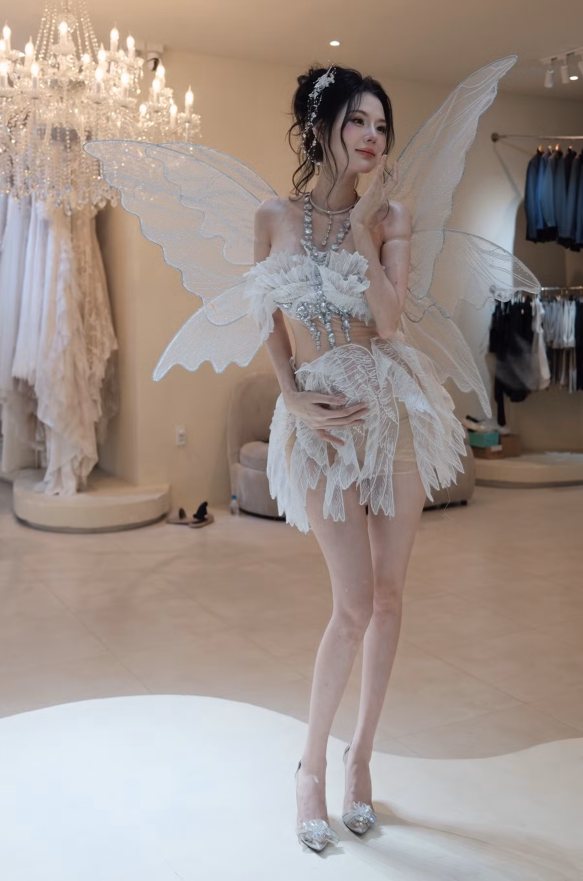 Linh Chi từng thực hiện bộ ảnh hóa thân thành nàng tiên với đôi cánh lấp lánh màu trắng bạc, trang phục váy ren bồng bềnh, cùng loạt phụ kiện cầu kỳ như dây chuyền bản lớn. Loạt ảnh này khoe được vẻ đẹp thoát tục, mong manh nhưng vẫn đầy quyến rũ của cô. (Ảnh: FBNV)