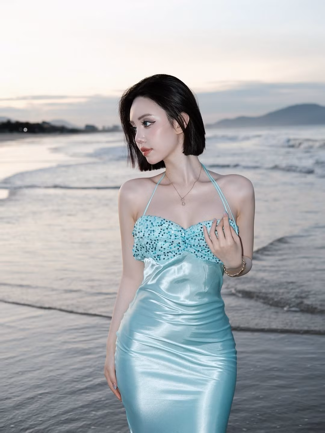 Trong loạt ảnh khác, Chu Mạc Thúy Quỳnh hóa thân thành "nàng tiên cá" kiêu sa trên bãi biển vào khoảnh khắc hoàng hôn lãng mạn. Cô diện một chiếc váy dài, ôm sát cơ thể với tông màu xanh ngọc bích, phần thân trên được đính sequin lấp lánh như vảy cá.