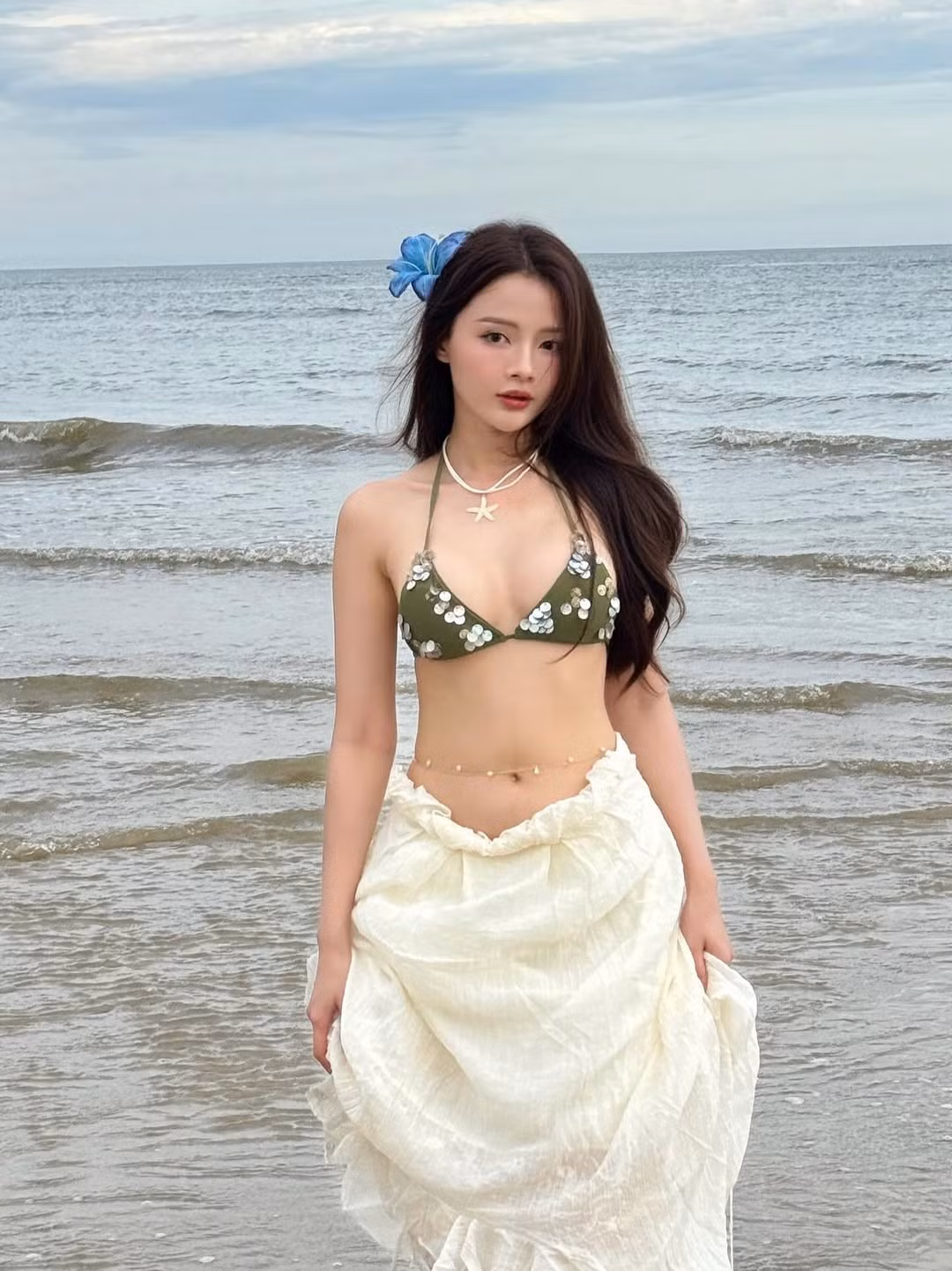 Chiếc bikini màu xanh olive với thiết kế dây buộc mảnh mai làm nổi bật làn da trắng mịn và những đường cong gợi cảm của cô. (Ảnh: IGNV)