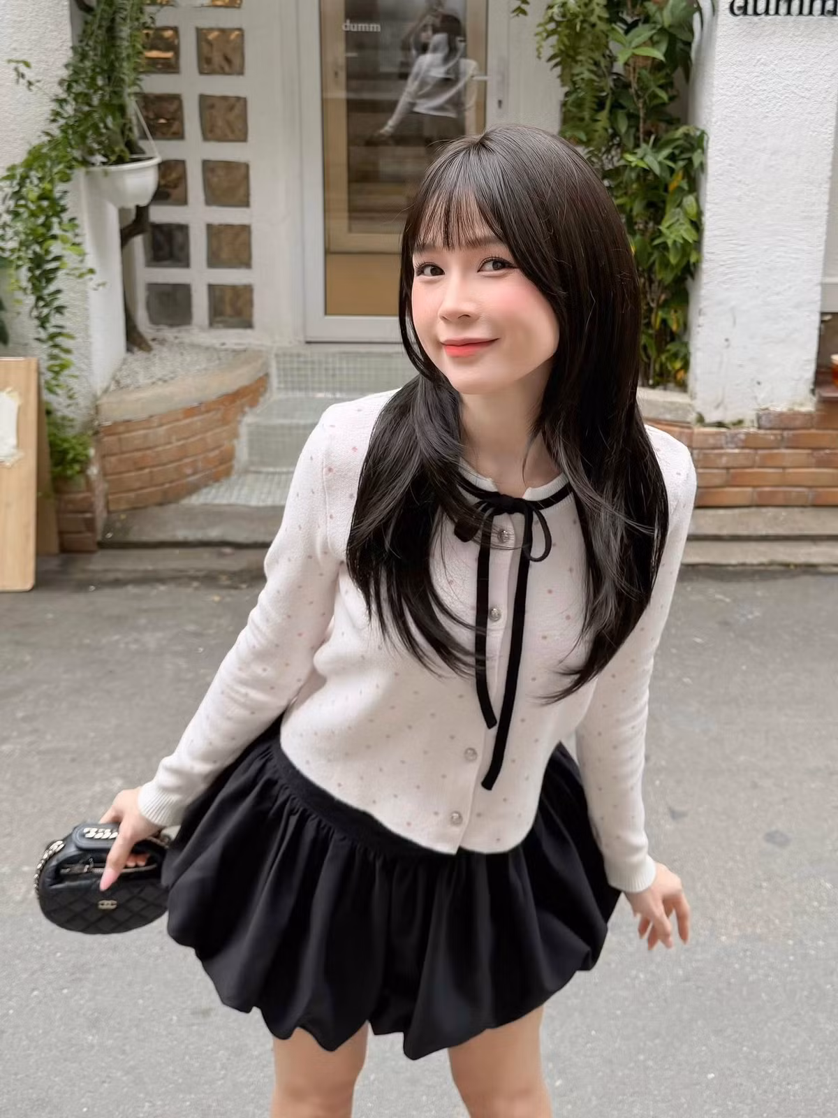 Cô nàng khéo léo kết hợp cùng tất cao cổ đen và giày Mary Jane đế bệt bóng bẩy - những "item" đặc trưng của phong cách học đường. Chiếc túi xách Chanel mini là điểm nhấn sang chảnh, hoàn thiện tổng thể trang phục. (Ảnh: IGNV)