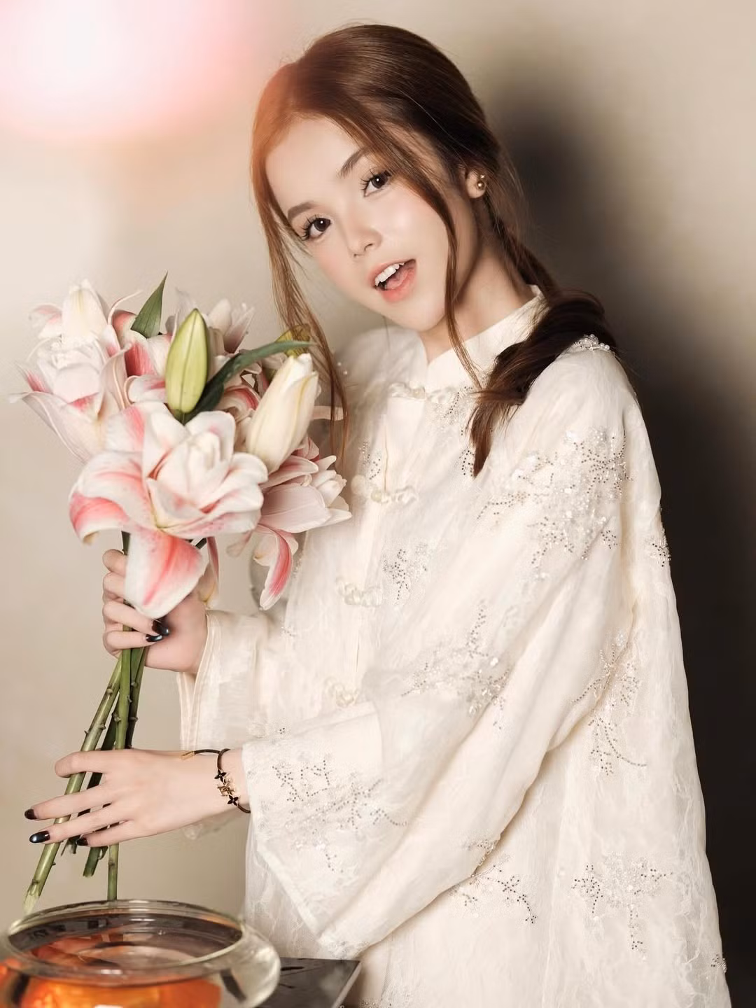 Trong bộ ảnh vừa chia sẻ, Lê Gia Linh lựa chọn bộ áo dài mang tông màu trắng kem nhã nhặn, điểm xuyết bằng những chi tiết đính kết lấp lánh tinh tế dọc thân áo. Thiết kế này không chỉ tôn lên làn da trắng sứ mà còn làm nổi bật nét thanh tao, nhẹ nhàng của cô nàng. (Ảnh: IGNV)