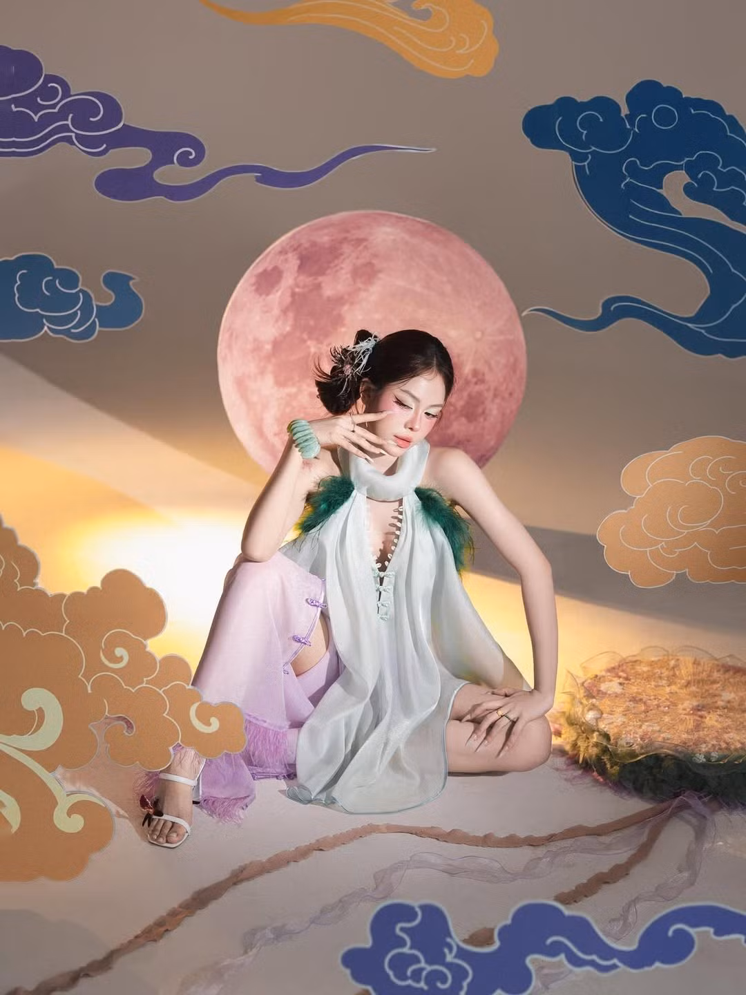 Toàn bộ khung hình được đặt trong bối cảnh đêm trăng rằm huyền ảo với hình ảnh mặt trăng lớn màu hồng tím cùng những đám mây ngũ sắc được sắp đặt cầu kỳ, tạo nên một không gian đậm chất kỳ ảo, thần thoại. (Ảnh: IGNV)