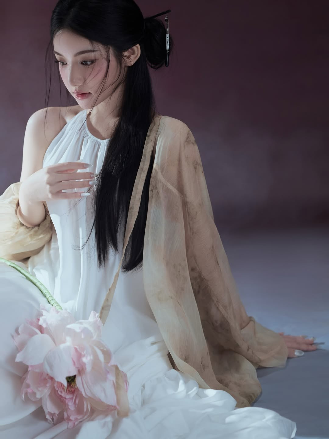 Chi tiết đóa hoa sen hồng cầm trên tay kết hợp cùng lối trang điểm trong veo giúp tôn lên làn da trắng mịn và gương mặt "búp bê" đặc trưng. (Ảnh: IGNV)