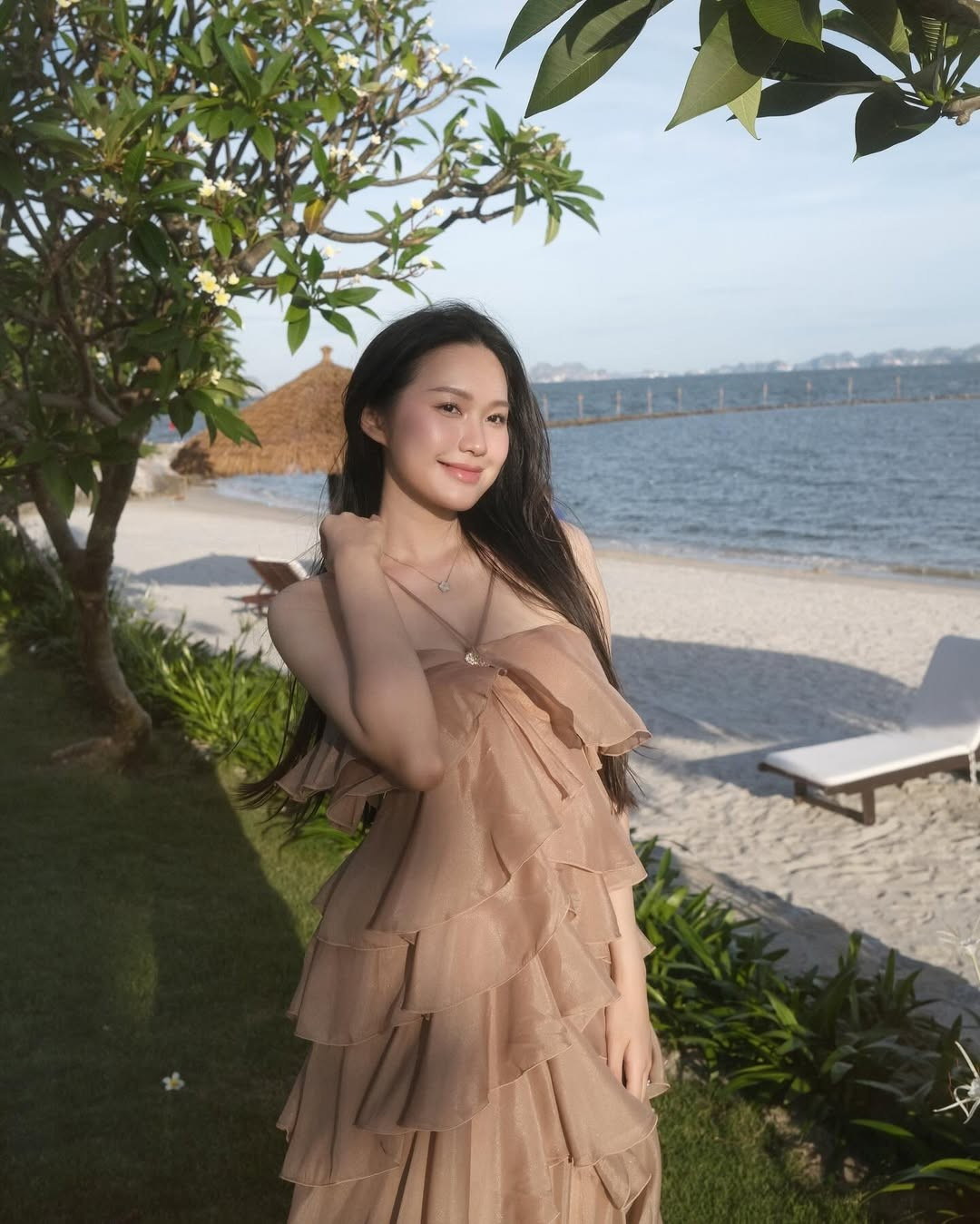 Làn tóc đen dài buông xõa tự nhiên cùng nụ cười nhẹ nhàng, e ấp càng làm tăng thêm vẻ đẹp thanh thoát của cô.