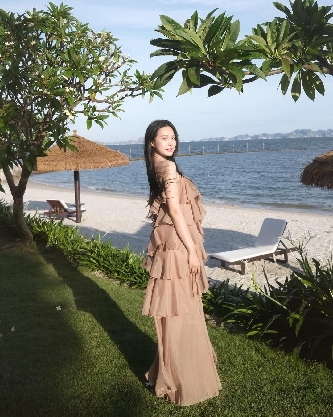 Background là bãi cát trắng mịn, hàng cây xanh mát và mặt biển trong xanh càng tôn lên vẻ đẹp thoát tục của nàng WAGs đình đám này.