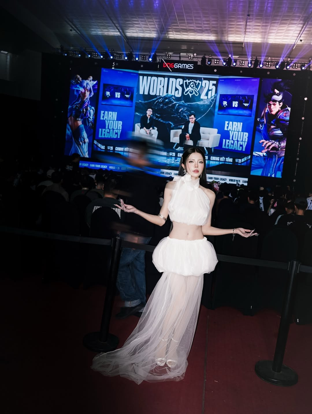 Cô nàng chọn một set đồ màu trắng tinh khôi với thiết kế độc đáo. Phần thân trên là áo crop top cổ yếm cao, khoe khéo vòng eo thon gọn, kết hợp cùng chân váy phồng xòe ngắn. (Ảnh: IGNV)