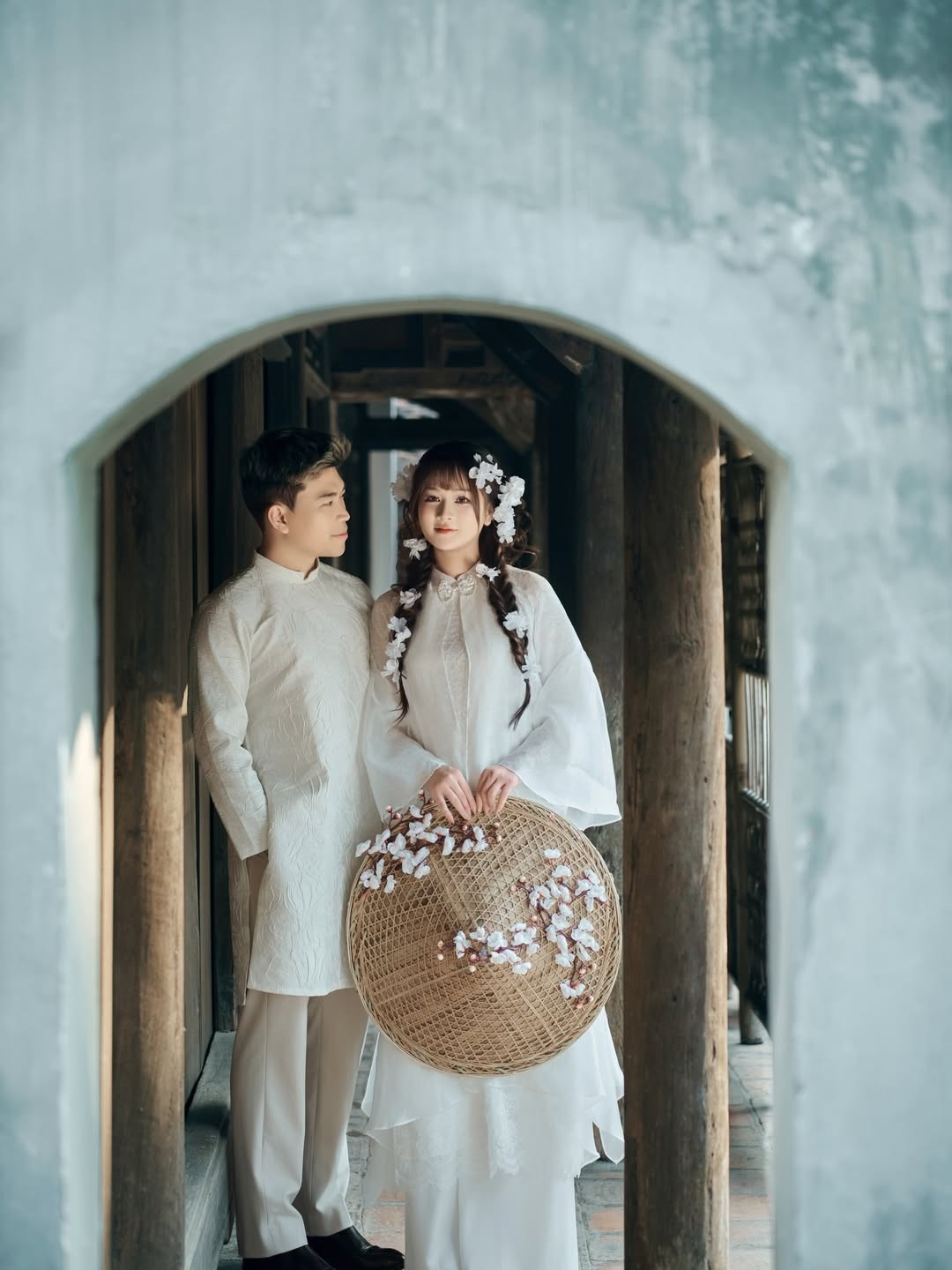 Cặp đôi không chọn những phim trường rực rỡ sắc màu mà tìm đến một không gian mang đậm tính nghệ thuật với những nét thô mộc, xưa cũ. Bối cảnh là không gian hoài cổ với những mảng tường xám trầm mặc, bộ bàn ghế gỗ đã nhuốm màu thời gian và những ô cửa sổ đón ánh sáng tự nhiên. (Ảnh: IGNV)