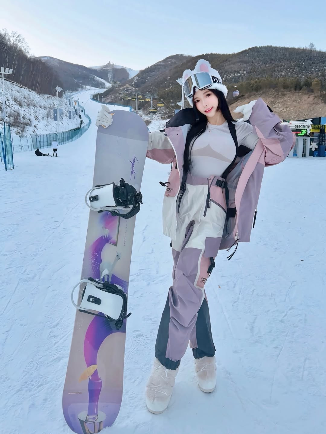 Amber Na khéo léo khoe vóc dáng thon gọn khi chỉ diện áo giữ nhiệt dệt kim màu trắng kem ôm sát bên trong bộ áo khoác. Thiết kế áo ôm sát, cổ tròn nhẹ nhàng nhưng vẫn tôn lên đường cong quyến rũ của cô. (Ảnh: IGNV)