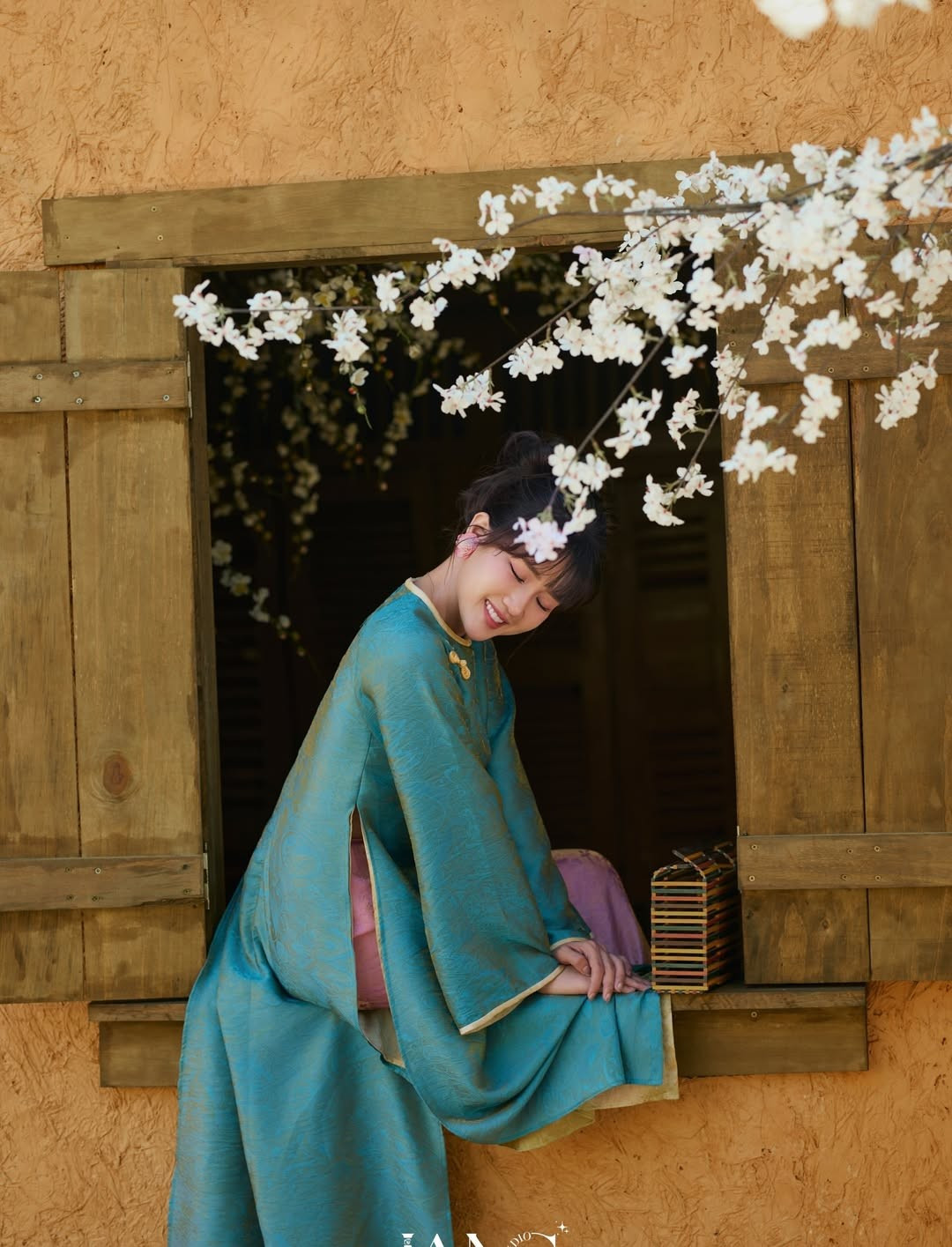 Dù là lúc tựa cửa nhìn xa xăm hay khi nở nụ cười rạng rỡ bên nhành hoa trắng, Kiều Trinh vẫn giữ được nét diễn tự nhiên, "diễn như không diễn". Ánh mắt biết nói và nụ cười tỏa nắng của cô chính là "vũ khí" khiến bộ ảnh trở nên có hồn hơn bao giờ hết. (Ảnh: IGNV)