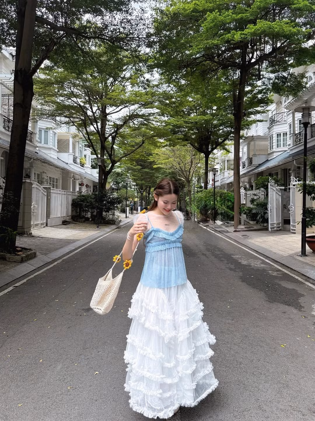 Mái tóc dài xoăn nhẹ tự nhiên cùng nụ cười rạng rỡ và ánh mắt biết cười khiến cô nàng trông như một nàng thơ bước ra từ câu chuyện cổ tích.