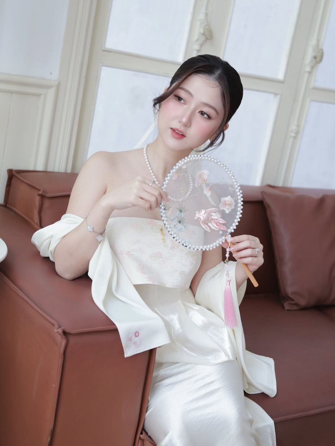 Trong outfir đầu tiên, cô nàng diện áo cúp ngực dáng yếm, khoe trọn bờ vai trần mảnh dẻ và làn da trắng sứ. Phần ngực áo được may hai lớp với lớp phủ bên ngoài in họa tiết hoa chìm tinh tế, tạo nên sự kín đáo nhưng vẫn đầy quyến rũ.(Ảnh: IGNV)