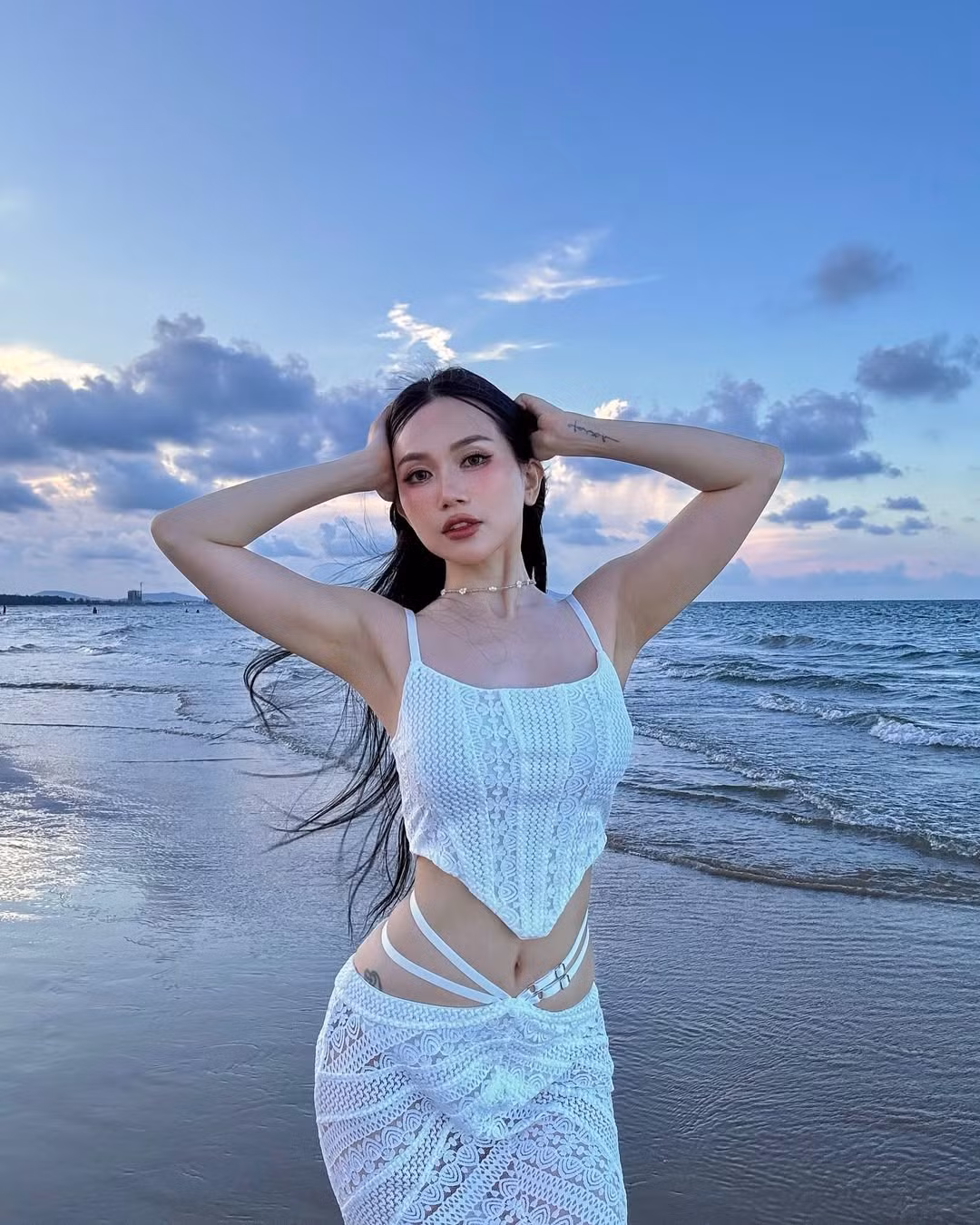 Phần thân áo được may dạng corset ôm sát, tôn vinh trọn vẹn đường cong gợi cảm của nữ nghệ sĩ. Chi tiết cut-out ở eo và hông được xử lý tinh tế, vừa quyến rũ vừa mang hơi thở hiện đại, cá tính.