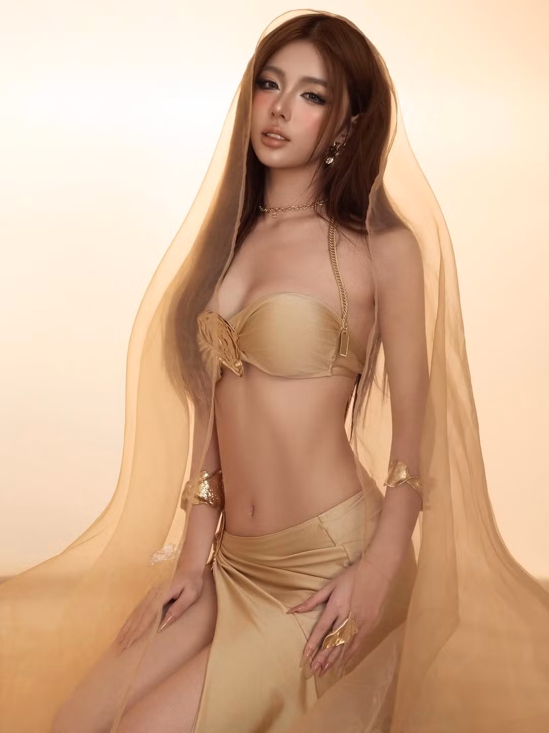 Nàng hot girl diện một bộ bikini cách điệu cùng chân váy xẻ cao táo bạo, khoe trọn vóc dáng mảnh mai và những đường cong nuột nà.