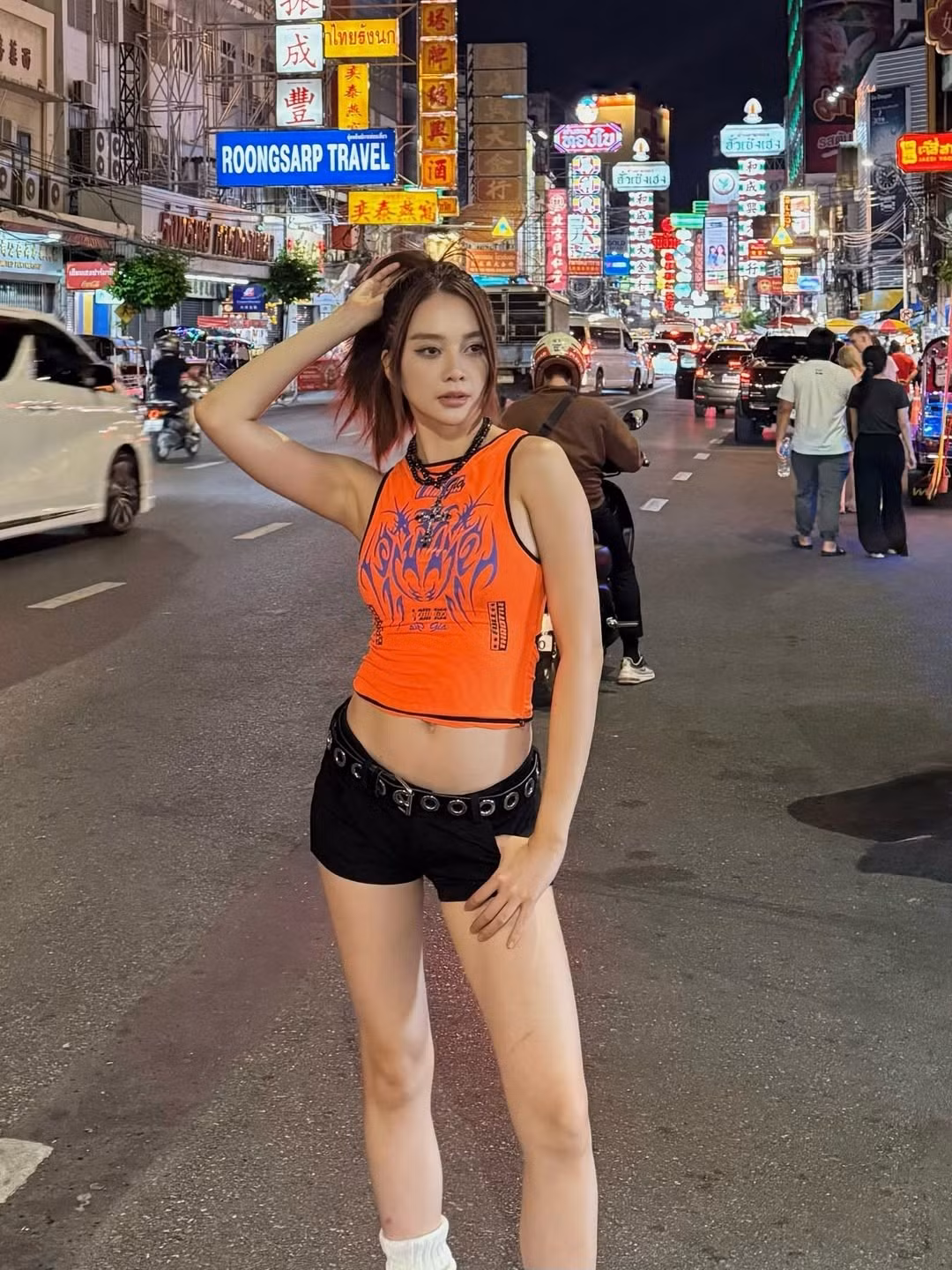 Để hoàn thiện set đồ "đi đu idol", Thiều Bảo Trang lựa chọn đôi tất cao cổ màu trắng và giày thể thao tông cam đồng điệu với áo, tạo nên tổng thể vừa năng động, bụi bặm lại vừa thời thượng, đúng chất một fan K-Pop thứ thiệt.