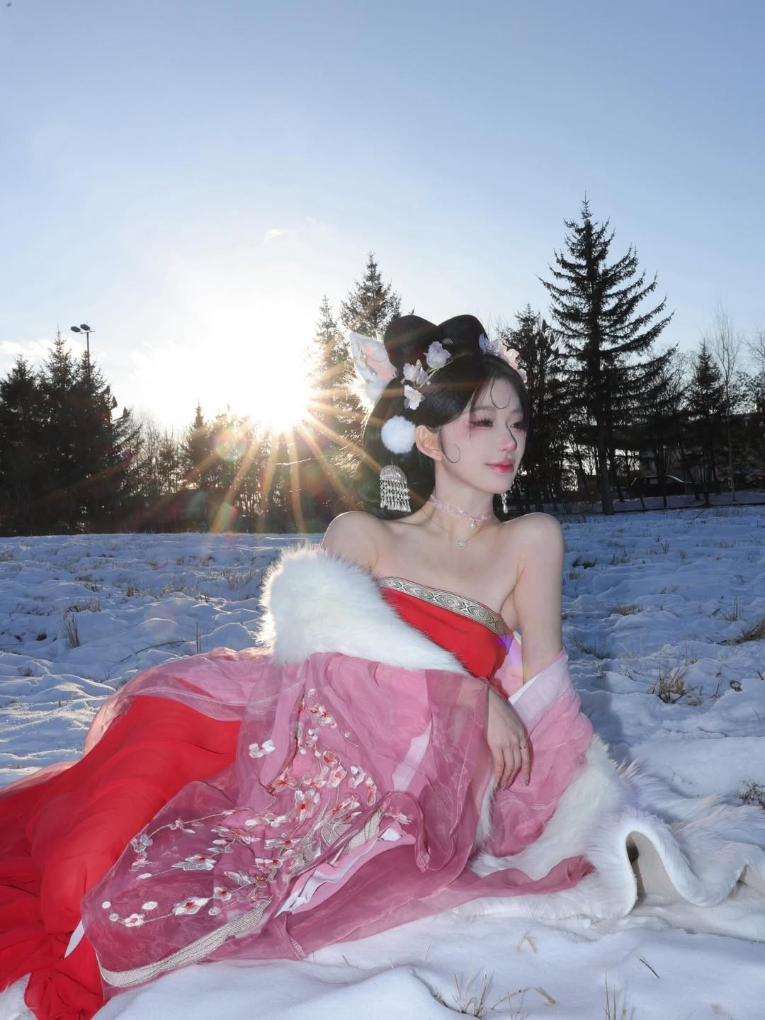 Cô diện một bộ trang phục cổ trang cách điệu, đặc trưng với phần vai trần, làm nổi bật nét quyến rũ và thanh thoát. Hai tông màu chủ đạo là đỏ rực và hồng phấn nhẹ nhàng tạo sự tương phản mạnh mẽ với nền tuyết. (Ảnh: IGNV)