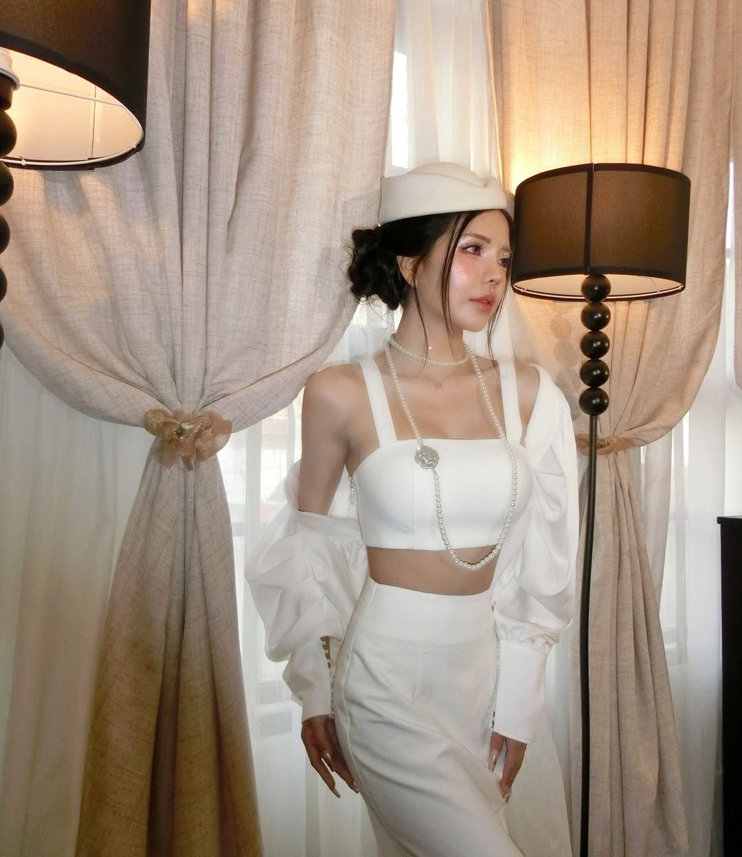 Để hoàn thiện vẻ ngoài sang chảnh, Mai Dora đã kết hợp cùng chuỗi vòng cổ ngọc trai nhiều lớp và chiếc mũ nồi đồng điệu. Sự kết hợp này mang hơi hướng của phong cách cổ điển, gợi nhớ đến vẻ đẹp của những biểu tượng thời trang thế kỷ trước. (Ảnh: IGNV)