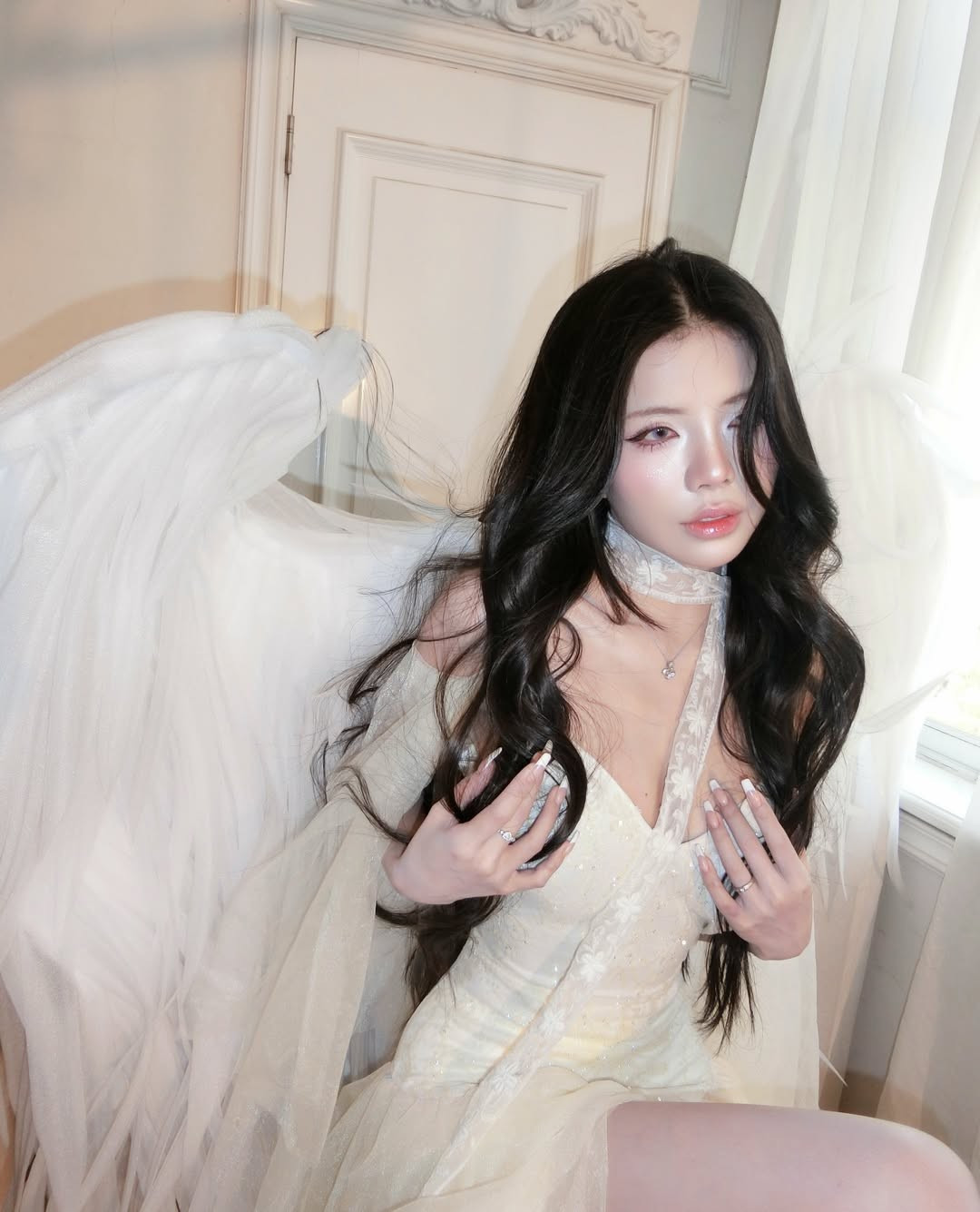 Trong bộ ảnh này, Mai Dora lựa chọn trang phục tông màu trắng kem tinh khôi, kết hợp cùng đôi cánh thiên thần lông vũ cỡ lớn. (Ảnh: IGNV)