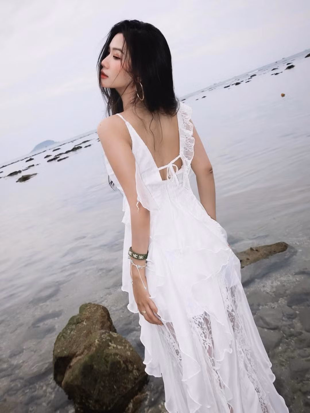 Trong bộ ảnh, Lylychuu diện một chiếc váy maxi trắng hai dây, được thiết kế tinh tế với nhiều tầng bèo nhún và chất liệu voan mỏng manh, bay bổng. (Ảnh: IGNV)