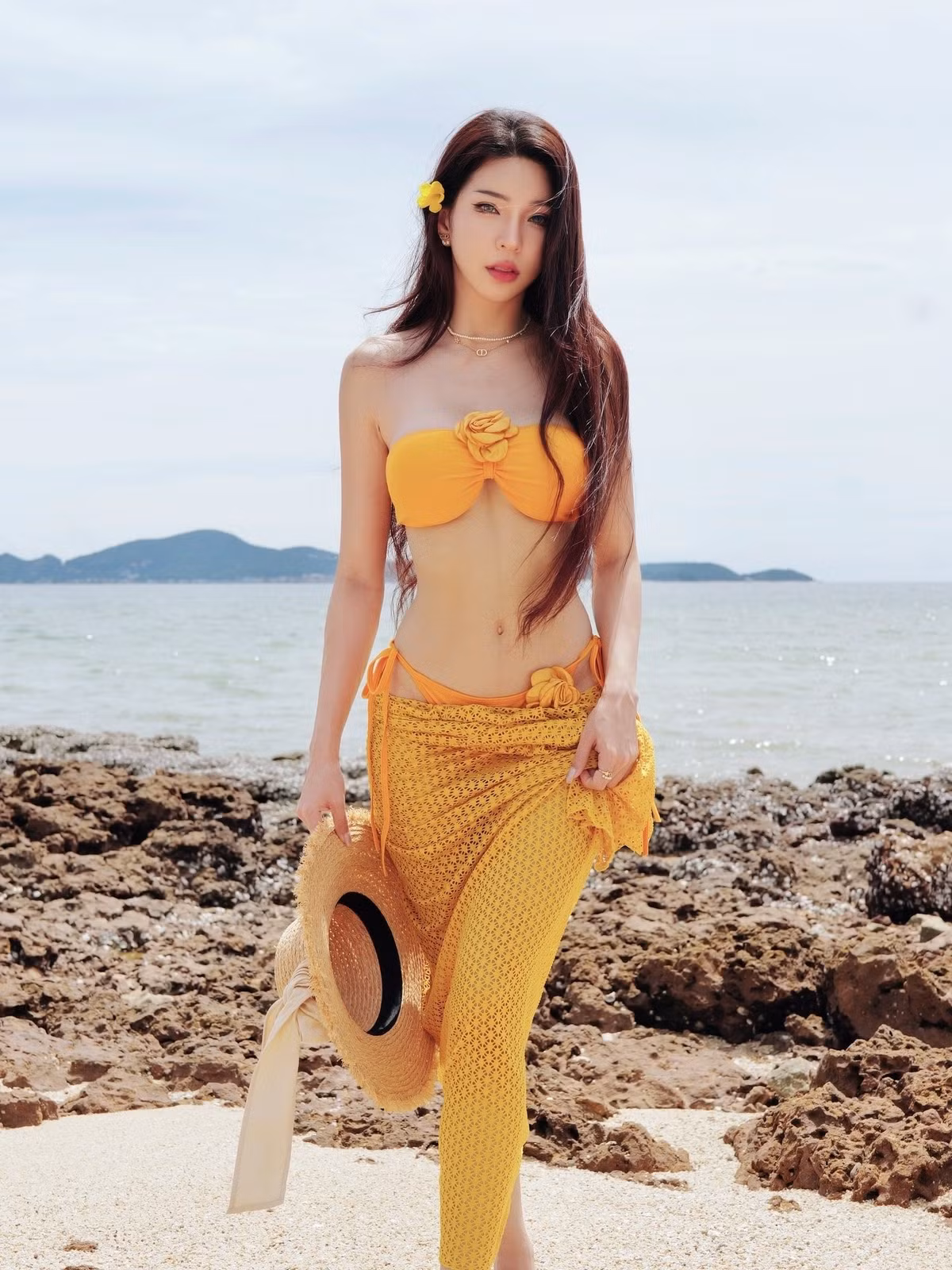 Đặc biệt, chiếc chân váy dài cạp trễ được làm từ chất liệu lưới, với họa tiết ren xuyên thấu, làm tăng thêm sự quyến rũ và ấn tượng. Kết hợp cùng chiếc mũ cói rộng vành, cô nàng toát lên vẻ đẹp vừa hoang dã, vừa đầy cuốn hút. (Ảnh: Facebook Janet Kanokwan Saesim)