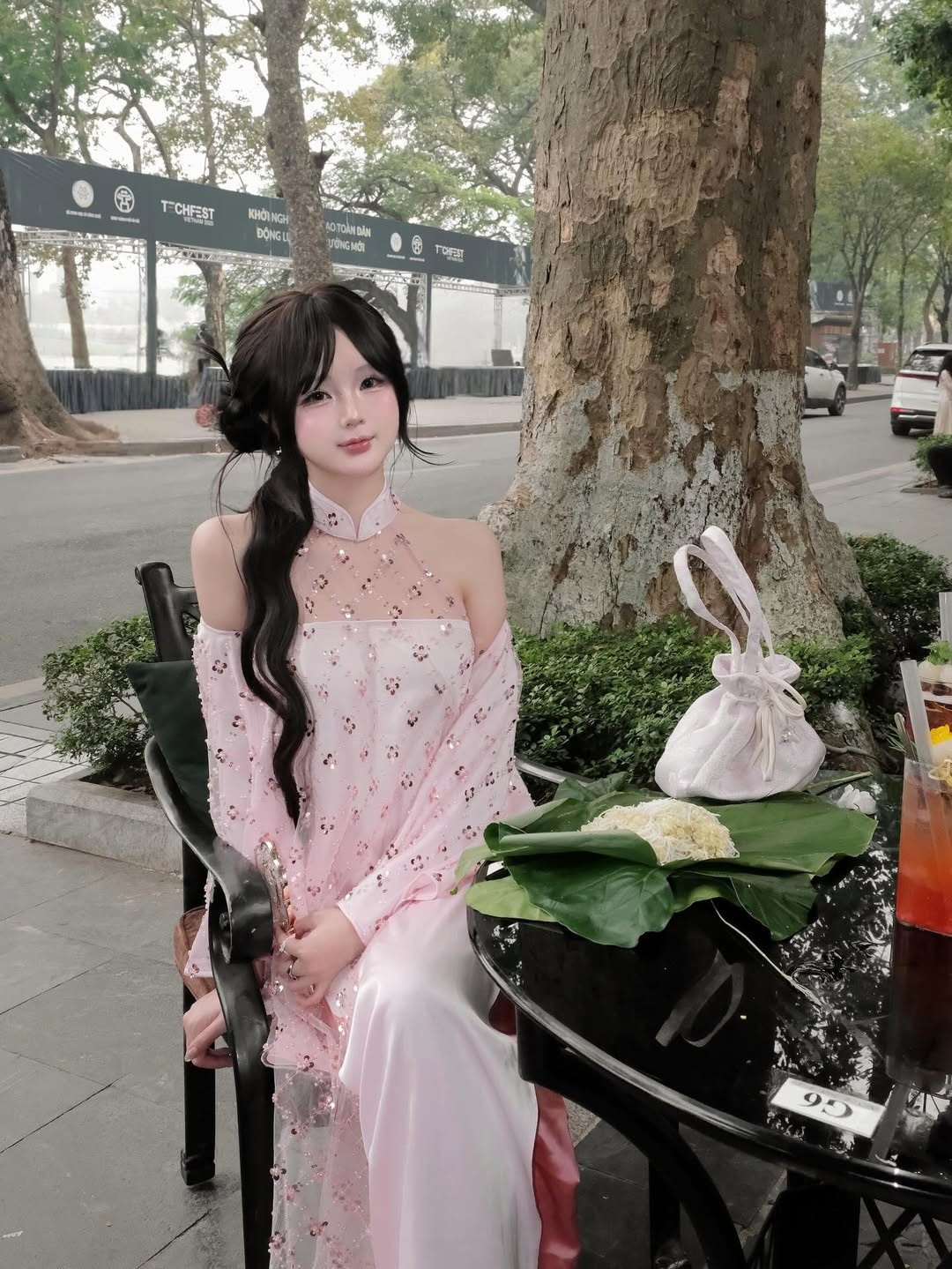 Hình ảnh Hạnh Nguyễn ngồi thưởng thức món ăn truyền thống của Hà Nội là xôi cốm bên khung cảnh Hồ Gươm cổ kính, nên thơ đã tạo nên sự kết hợp hài hòa giữa nét đẹp con người và văn hóa Thủ đô. (Ảnh: IGNV)