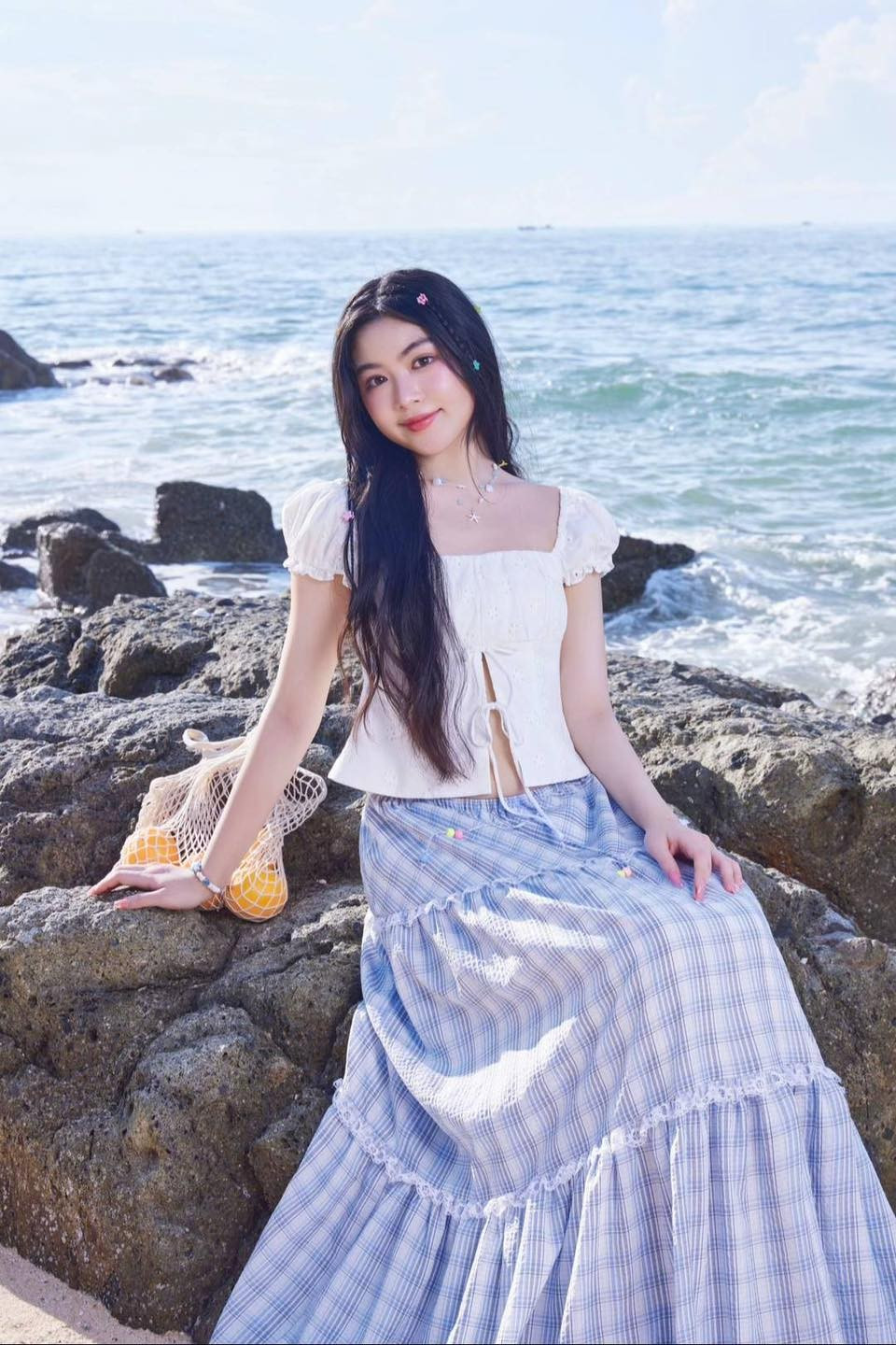 Outfit đơn giản nhưng thể hiện gu thẩm mỹ tinh tế của Lọ Lem với áo croptop trắng có tay bồng cổ điển kết hợp chân váy dài họa tiết kẻ caro tím pastel.