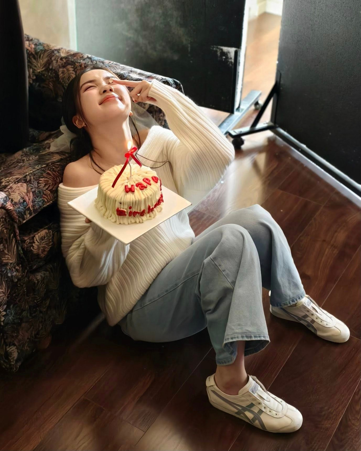 Điểm nhấn đáng yêu của bộ ảnh chính là chiếc mũ sinh nhật bằng ren trắng điệu đà và chiếc bánh kem nhỏ xinh với dòng chữ "Happy Birthday" đỏ rực. (Ảnh: FBNV)