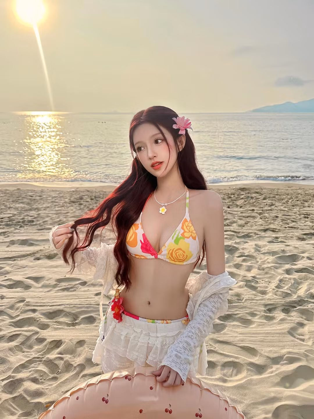 Trong loạt ảnh, Mỹ Uyên diện bikini họa tiết hoa rực rỡ, kết hợp cùng chiếc váy ren trắng mỏng nhẹ và áo khoác ngoài đồng điệu, tạo nên một tổng thể vừa quyến rũ vừa nữ tính, bay bổng. (Ảnh: IGNV)