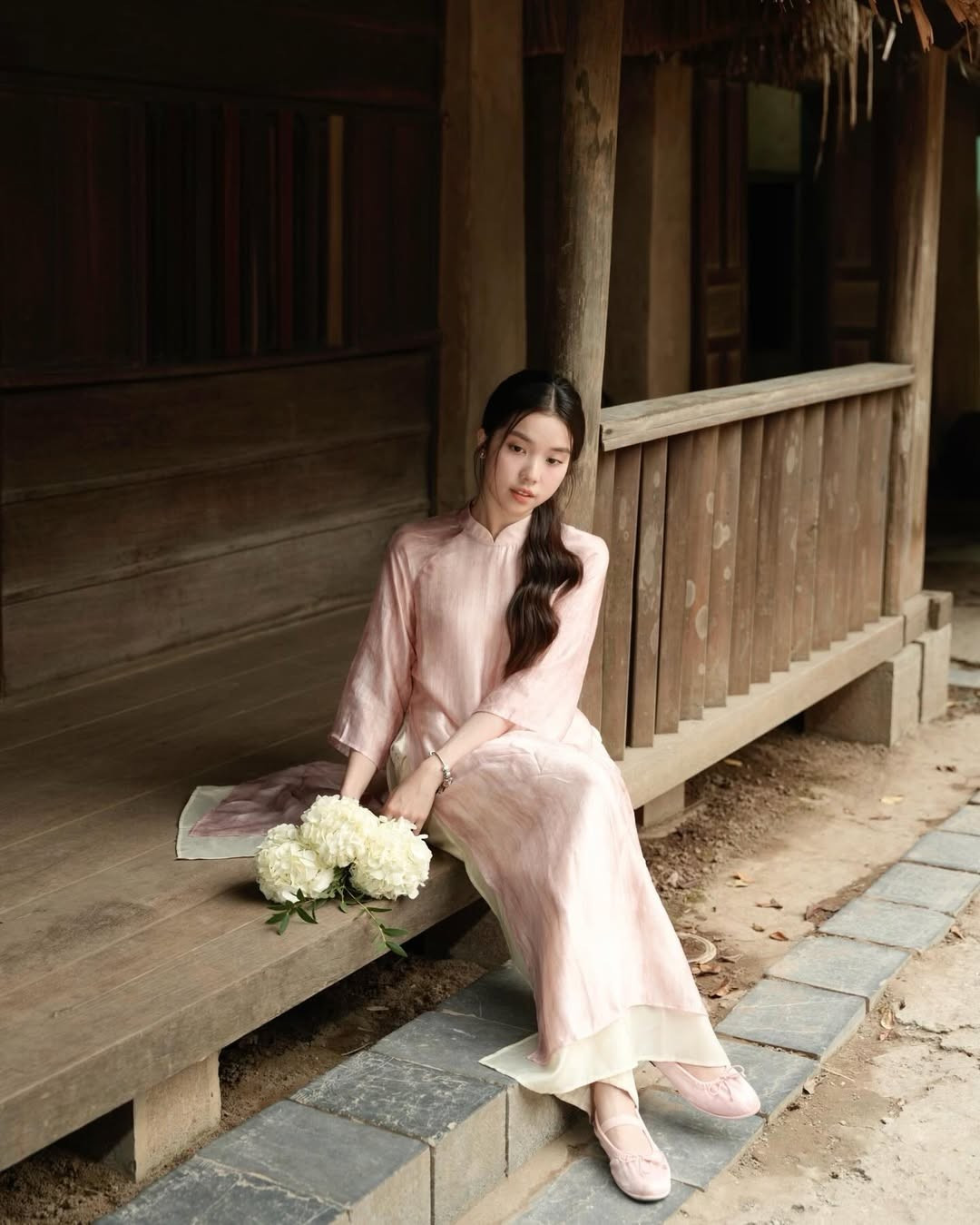 Cô nàng thực hiện bộ ảnh tại một không gian kiến trúc cổ kính, mang đậm nét nhà truyền thống Bắc Bộ. Những hình ảnh chụp tại hiên nhà, bậc cửa gỗ, mái ngói rêu phong hay khung cửa sổ có chấn song, đều mang lại cảm giác an yên, cổ kính. (Ảnh: IGNV)