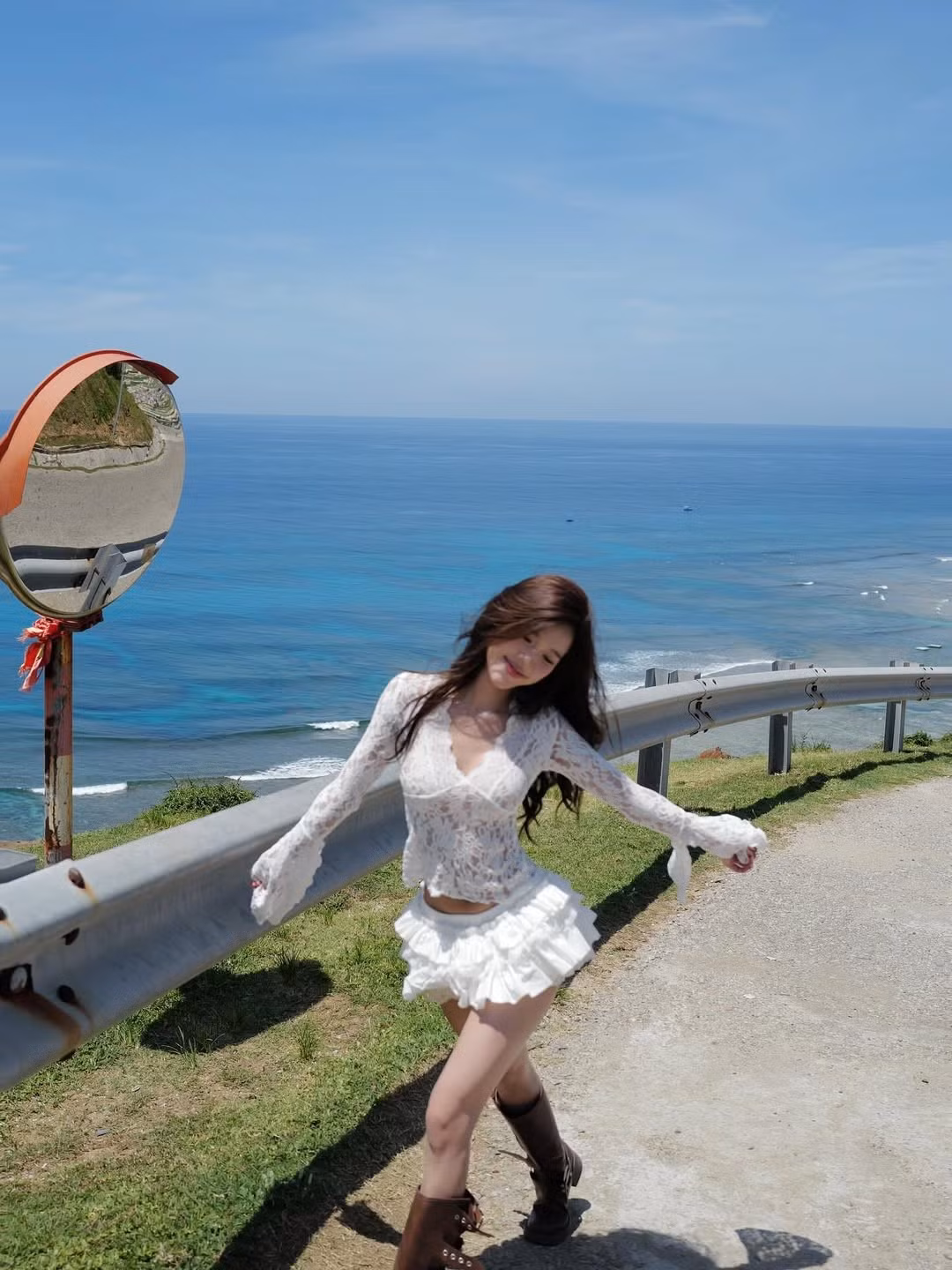 Bối cảnh chụp ảnh là một vách đá nhìn ra biển cả bao la, với nước biển xanh biếc và bầu trời trong vắt, tạo nên một phông nền hoàn hảo cho vẻ đẹp của Wyn Anh.