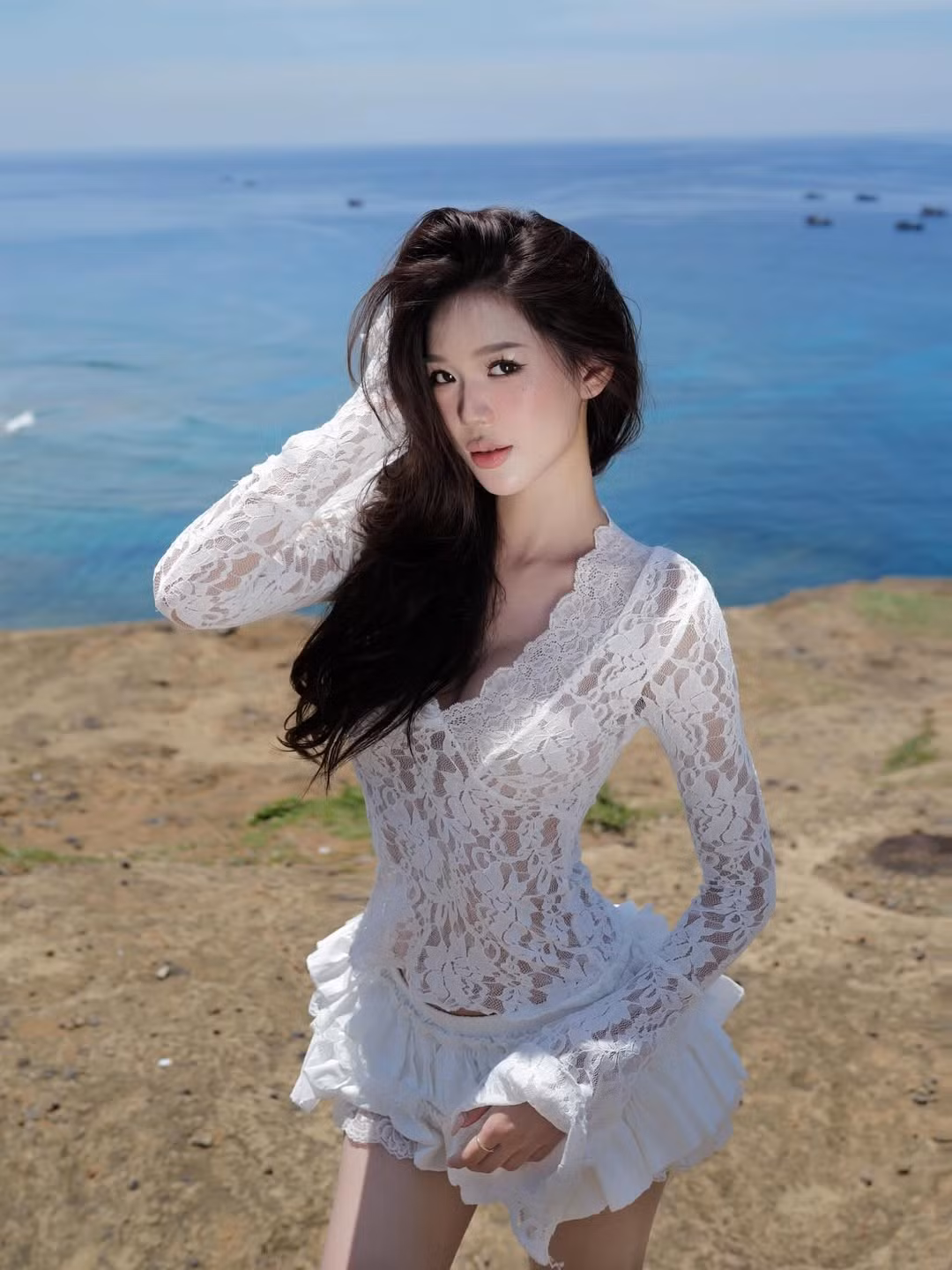 Với nhan sắc trong trẻo cùng vóc dáng cân đối, Wyn Anh đã chinh phục người xem trong trang phục ren trắng tinh khôi, nổi bật giữa khung cảnh biển xanh nắng vàng.