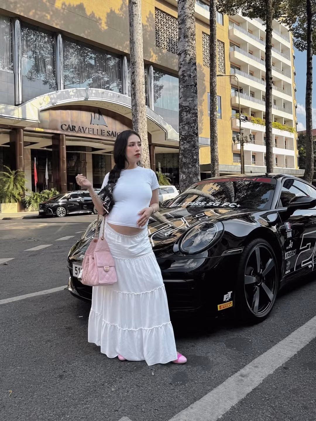 Người đẹp sinh năm 1999 mặc dù đã ở tháng thứ 9 của thai kỳ những vẫn chăm chỉ lên đồ ấn tượng. Trong bộ ảnh dạo phố mới nhất, con gái Minh Nhựa tự tin tạo dáng bên chiếc siêu xe Porsche màu đen bóng bẩy, toát lên vẻ sang chảnh và thời thượng.