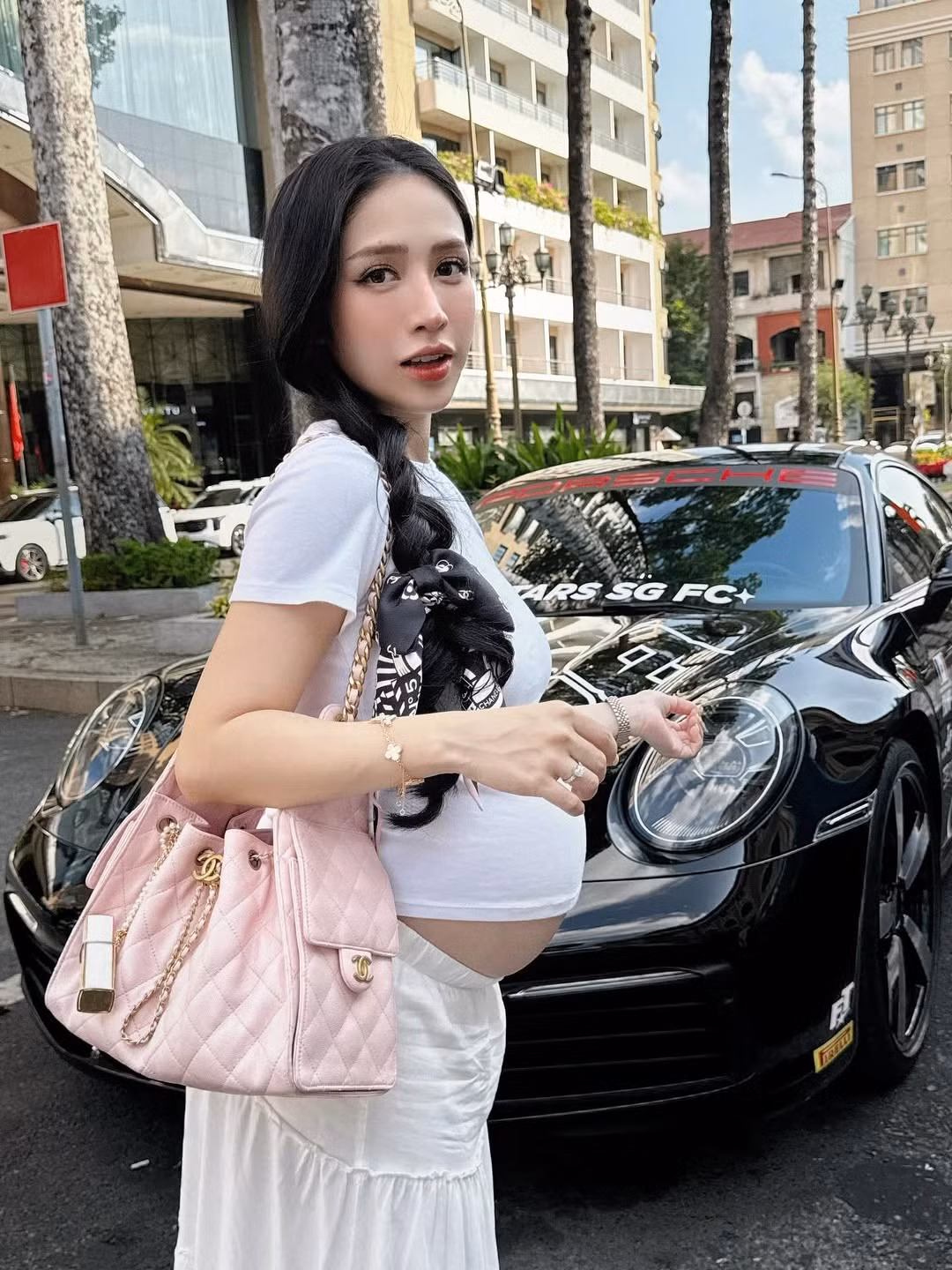 Điểm nhấn không thể thiếu là chiếc túi xách hàng hiệu màu hồng phấn nổi bật, tô điểm thêm nét nữ tính và trẻ trung cho set đồ.