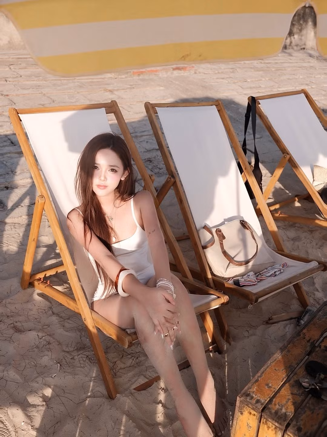 Kết hợp cùng chiếc mũ rộng vành bằng cói, túi cói và trái dừa tươi, tổng thể trang phục mang đến vẻ đẹp cổ điển, lãng mạn, đúng chất nghỉ dưỡng. Vẻ mặt ngây thơ, đôi mắt to tròn cùng nụ cười nhẹ của Thư Thỏ càng làm tăng thêm sự ngọt ngào cho set đồ này.