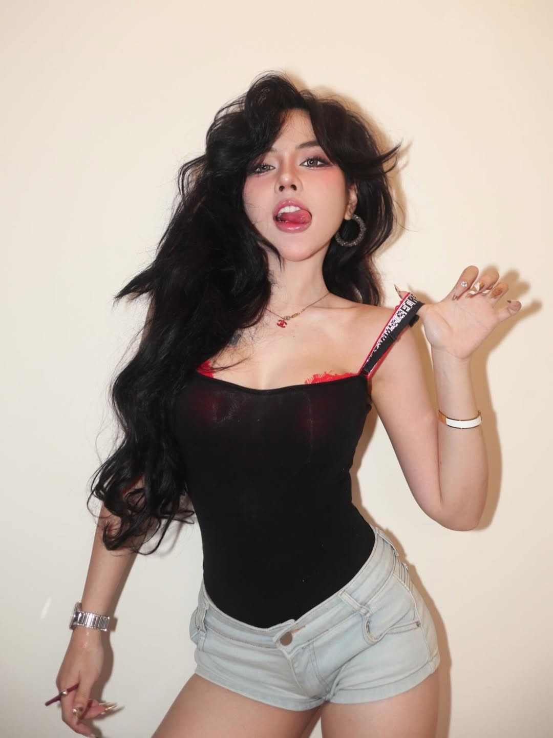 Mới đây, trên trang cá nhân của mình, Bảo Khuyên Susan (tên thật là Nguyễn Lê Bảo Khuyên, sinh năm 2001) đã chia sẻ những hình ảnh mới đầy cuốn hút kèm dòng trạng thái: "Fomo áo dây Victoria Secret". Cô nàng xuất hiện trong outfit kết hợp đầy táo bạo với một chiếc áo hai dây đen ôm sát, để lộ phần viền nội y ren đỏ rực rỡ và dây áo in logo đặc trưng của nhà Victoria's Secret. (Ảnh: IGNV)