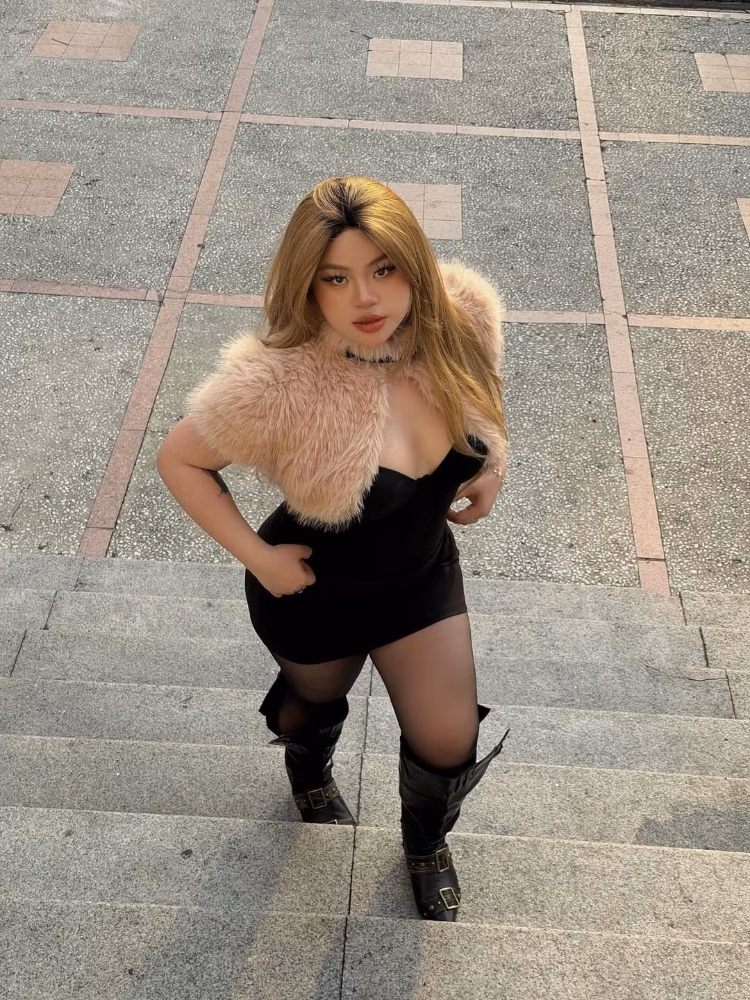 Dù là khi sải bước trên phố hay lúc ngồi tạo dáng trên những bậc thang đá, Cố Hữu Vi đều toát lên vẻ tự tin rạng rỡ. Đôi boots cao cổ da đen với thiết kế hầm hố, kết hợp cùng tất lưới mỏng không chỉ là lựa chọn thời trang phá cách mà còn giúp đôi chân trông thon gọn và săn chắc hơn. (Ảnh: IGNV)