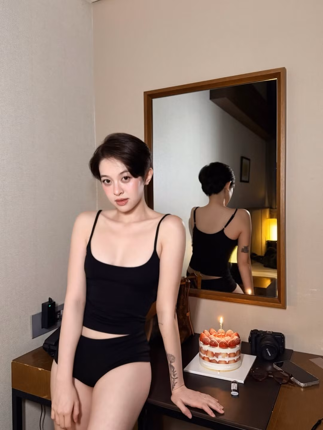 Chiếc bánh kem phủ đầy dâu tây đỏ mọng với một ngọn nến lung linh là "đạo cụ" chính, tạo nên sự tương phản màu sắc thú vị với tông màu trầm của căn phòng.(Ảnh: IGNV)