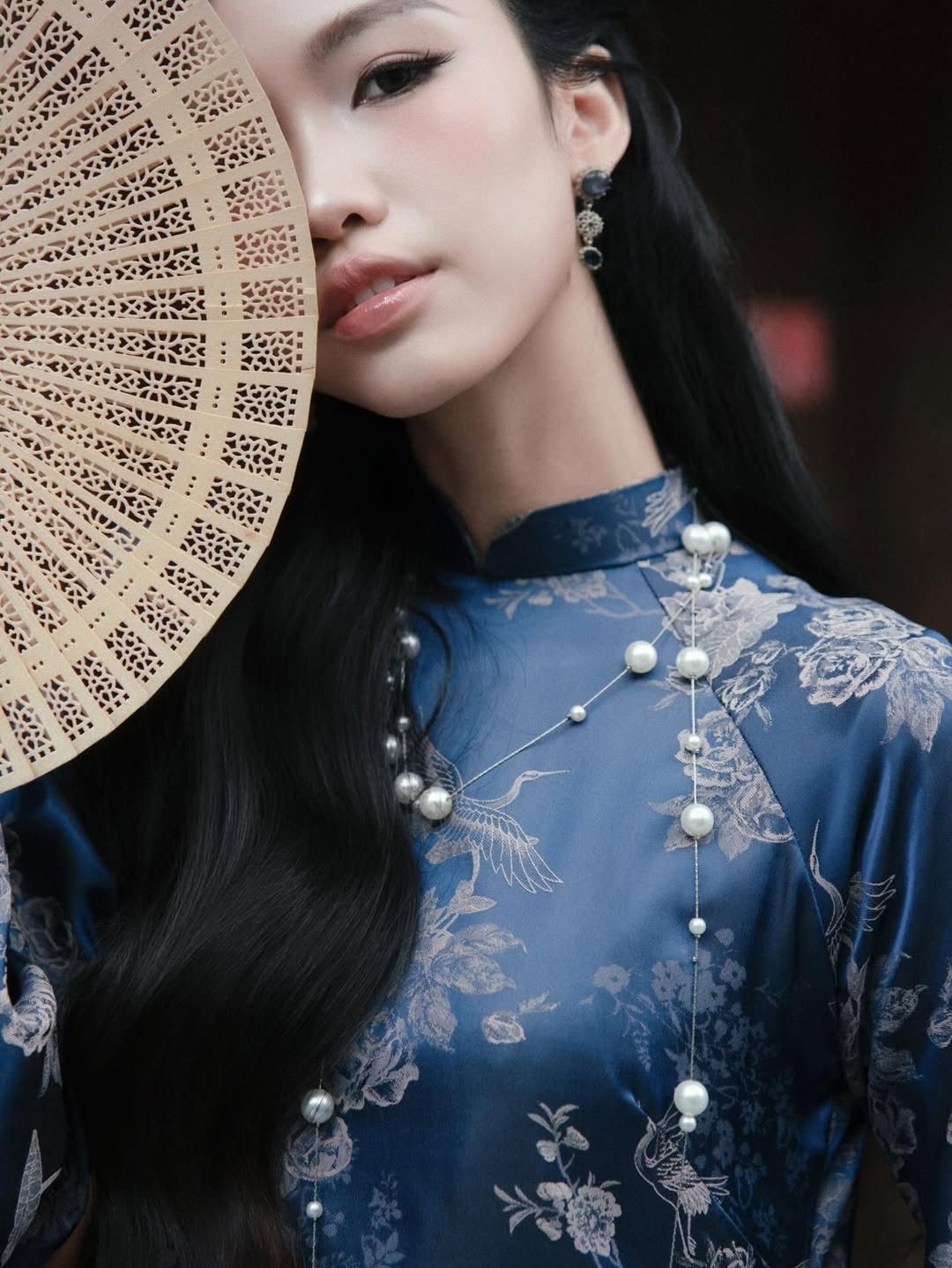 Kiểu tóc đen dài uốn sóng nhẹ, buộc nửa đầu vừa giúp cô giữ được nét truyền thống, vừa không bị "dìm" tuổi. (Ảnh: IGNV)