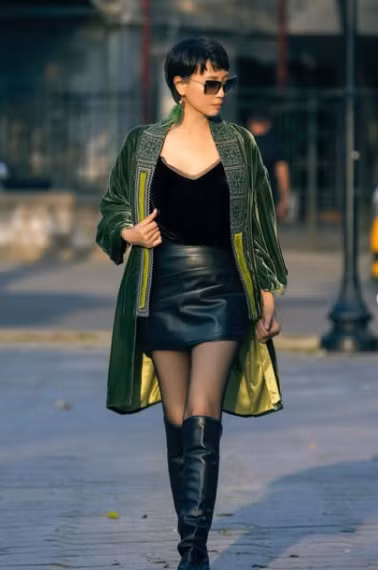 Trong loạt ảnh mới nhất, bà khéo léo phối hợp áo choàng nhung xanh - một thiết kế sang trọng với phần họa tiết thêu tỉ mỉ dọc vạt áo, tạo cảm giác vừa cổ điển vừa quyền lực, cùng với đó là chân váy da ngắn giúp tôn lên đôi chân dài miên man và vóc dáng thon gọn. (Ảnh IGNV)