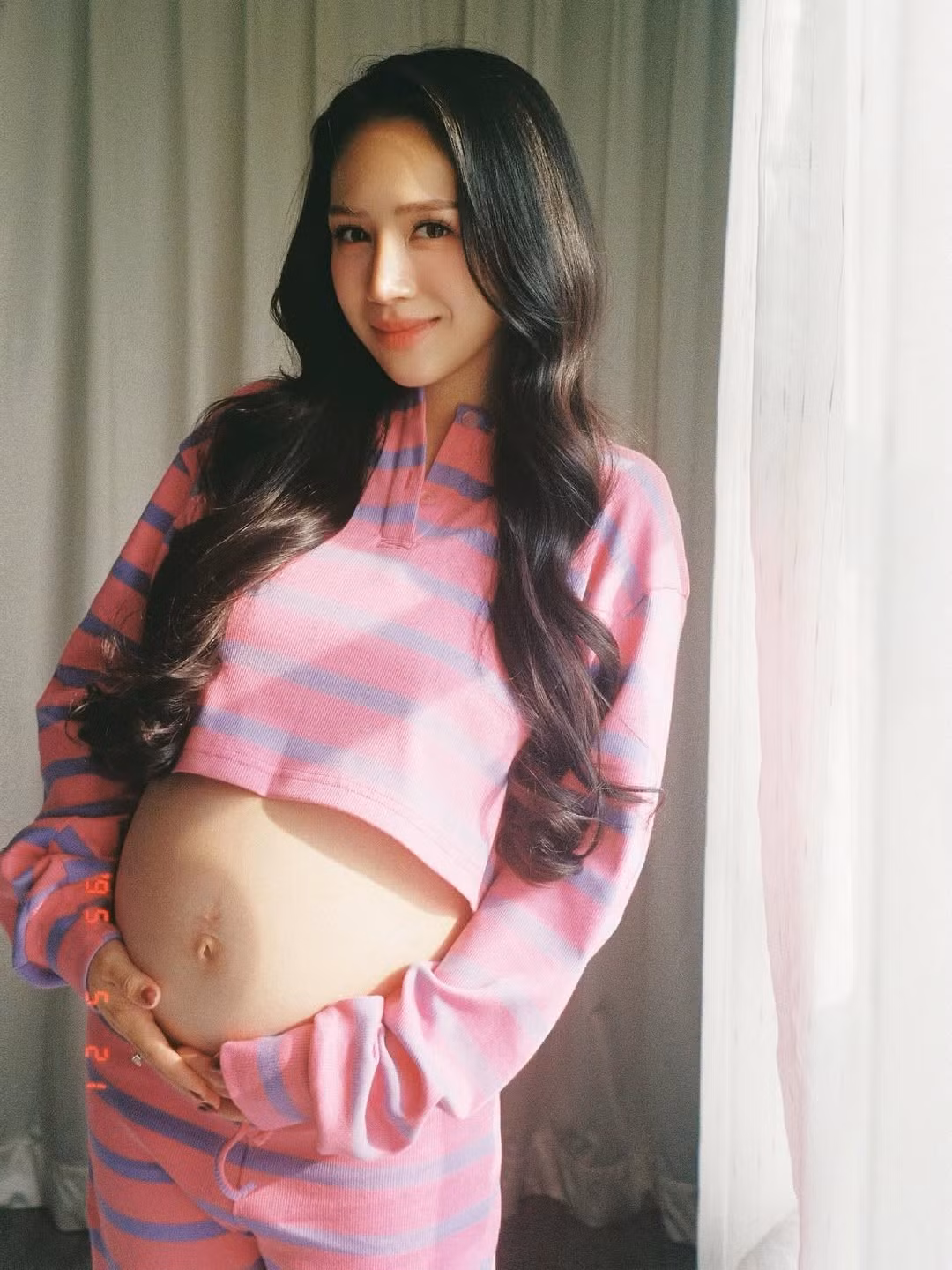 Trong loạt ảnh được chia sẻ, cô diện một set đồ thun crop-top và quần dài, với họa tiết kẻ sọc ngang màu hồng và xanh pastel đầy trẻ trung và năng động.