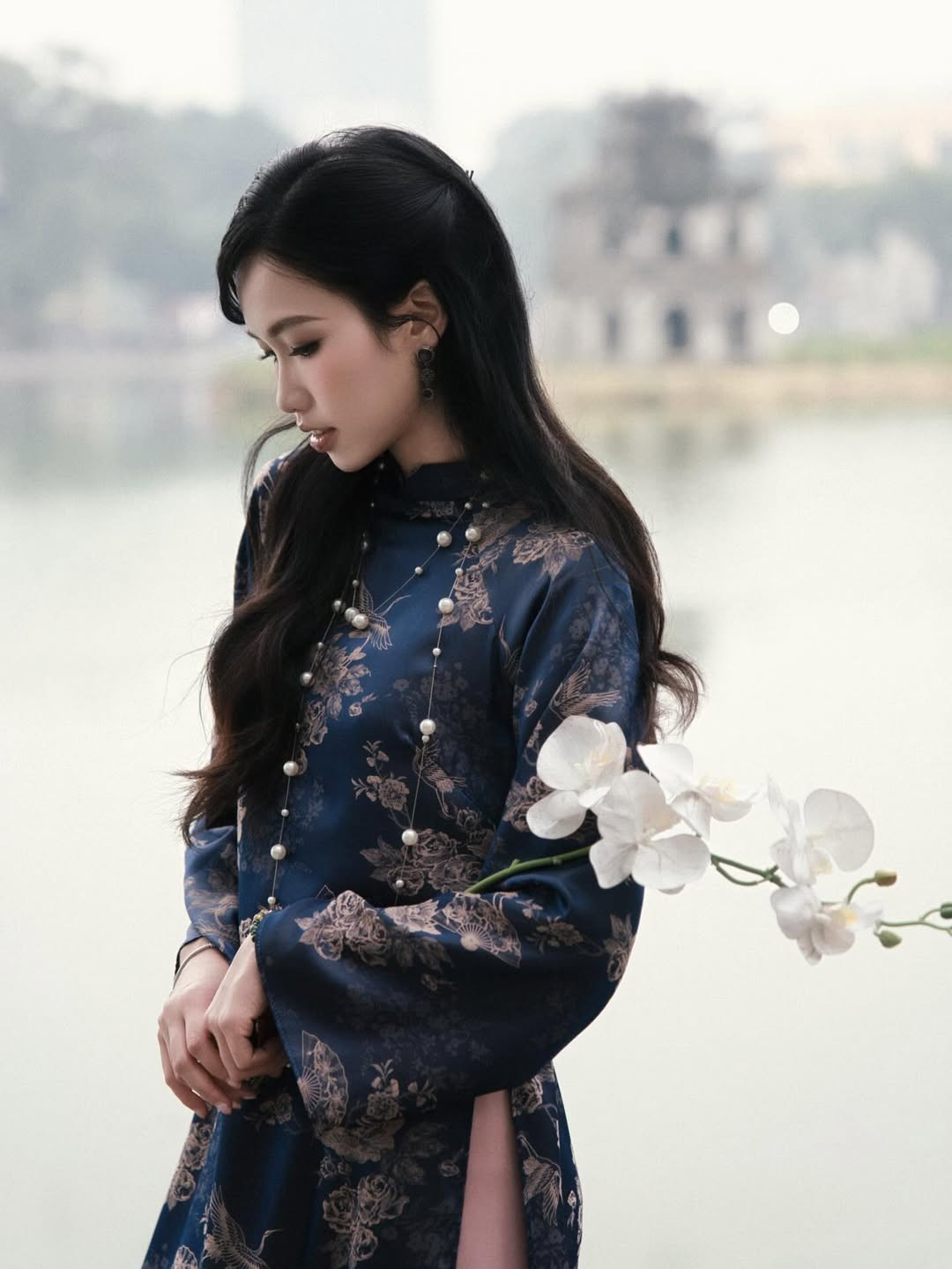 Thiết kế áo dài phom dáng truyền thống với phần tay lỡ và cổ cao giúp tôn lên bờ vai thanh mảnh. Sự kết hợp giữa sắc xanh của tà áo và quần lụa hồng pastel tạo nên một tổng thể hài hòa, vừa quyền quý vừa có nét thanh tao. (Ảnh: IGNV)